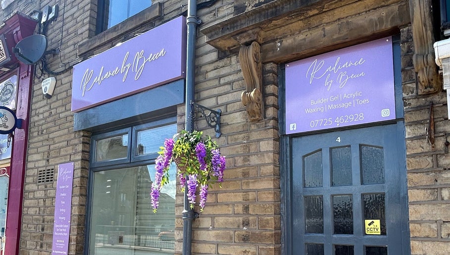 Radiance By Becca entrance in Halifax, England with purple signage and flowers enhancing the beauty venue.