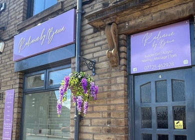 Radiance By Becca entrance in Halifax, England with purple signage and flowers enhancing the beauty venue.