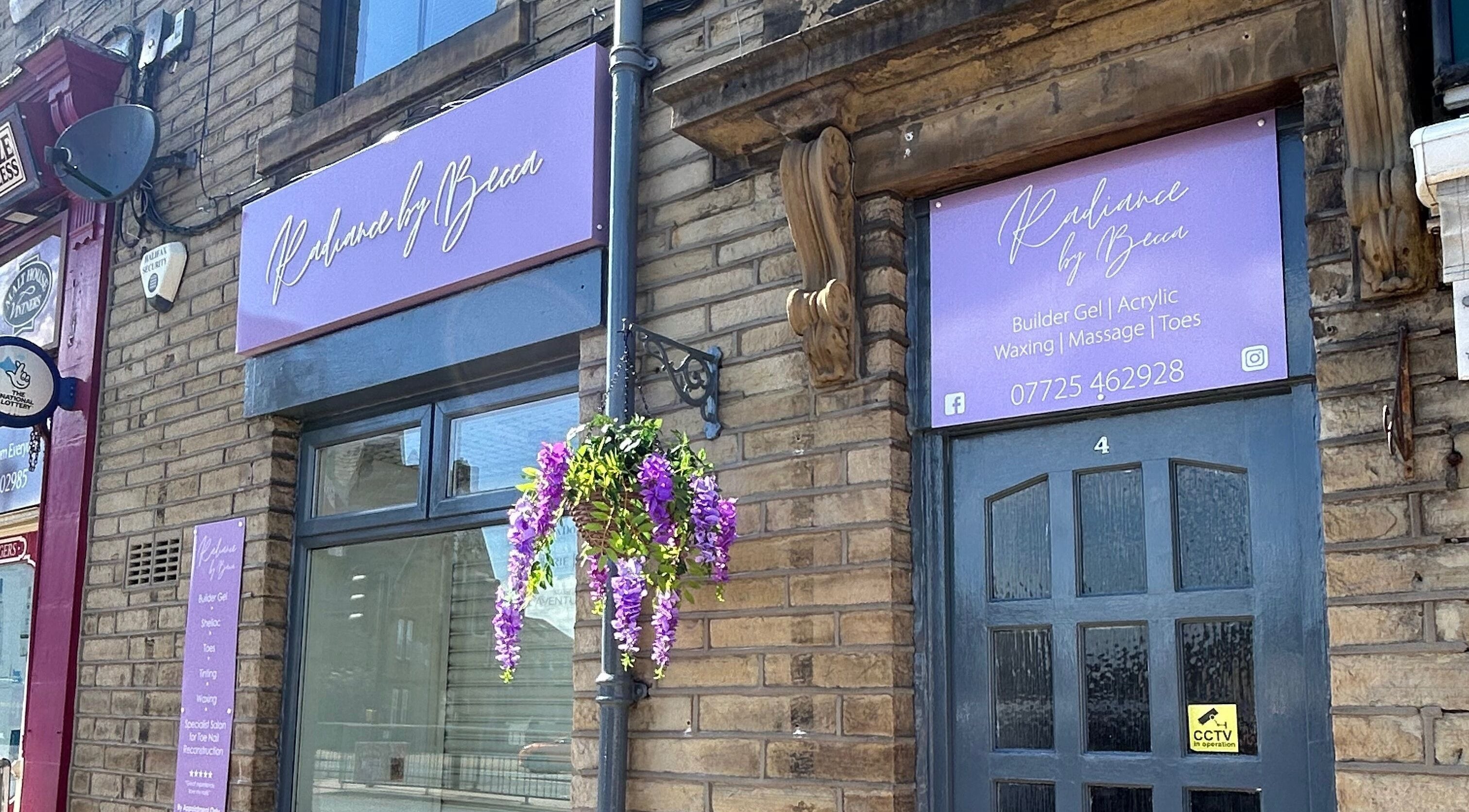 Radiance By Becca entrance in Halifax, England with purple signage and flowers enhancing the beauty venue.