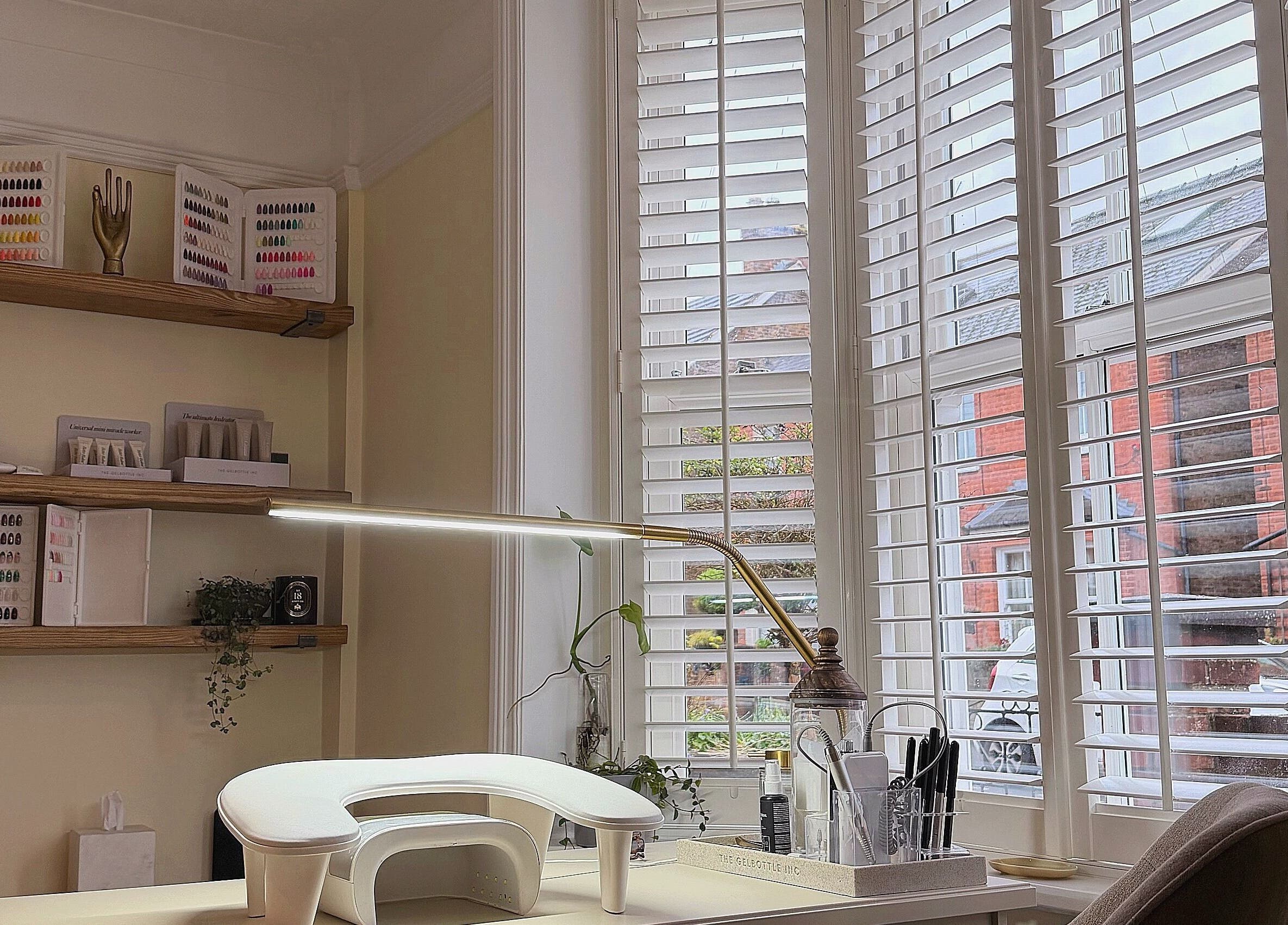 The Sulking Room in Horsham, England showcases a serene nail station with ample natural light and organized polishes.