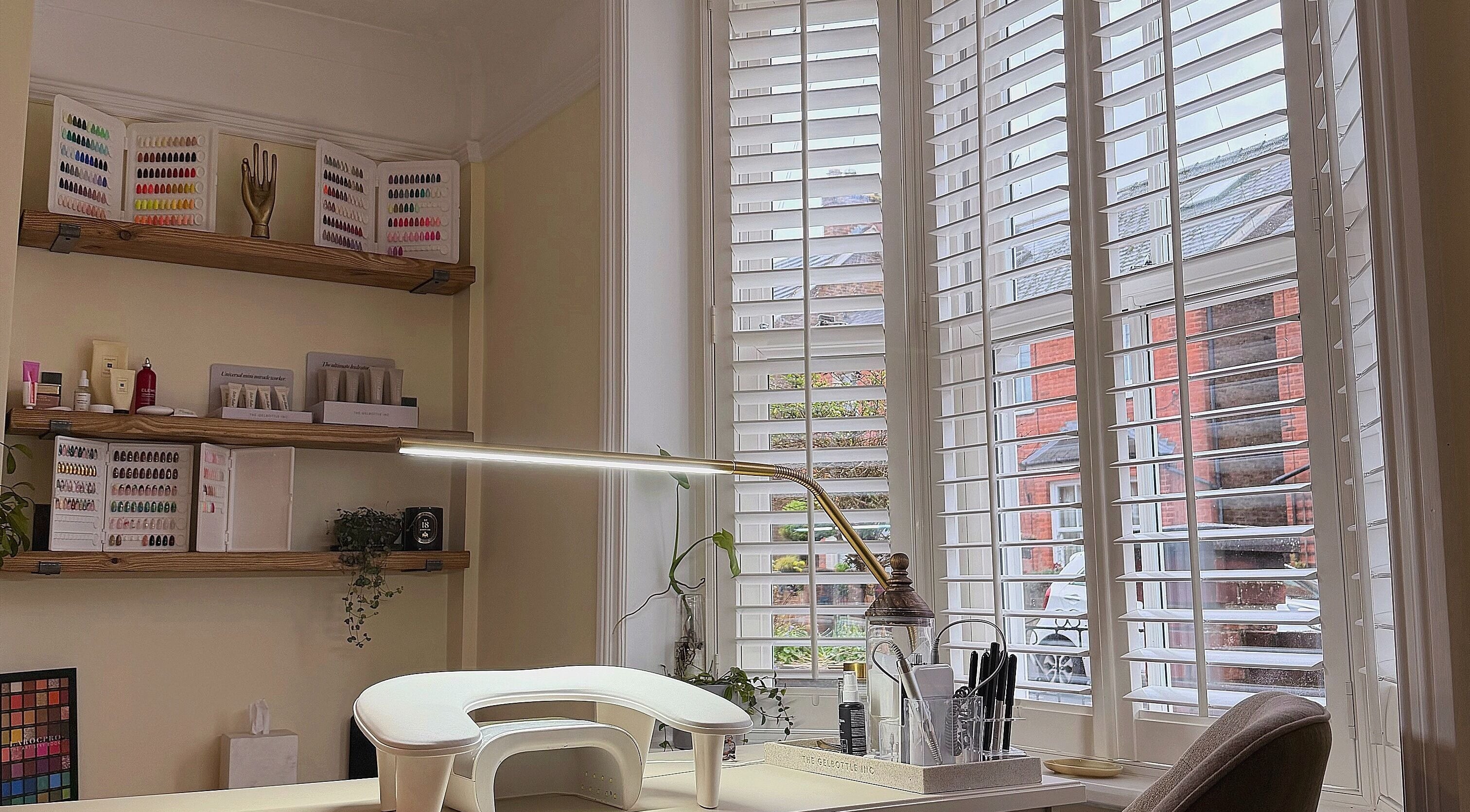 The Sulking Room in Horsham, England showcases a serene nail station with ample natural light and organized polishes.