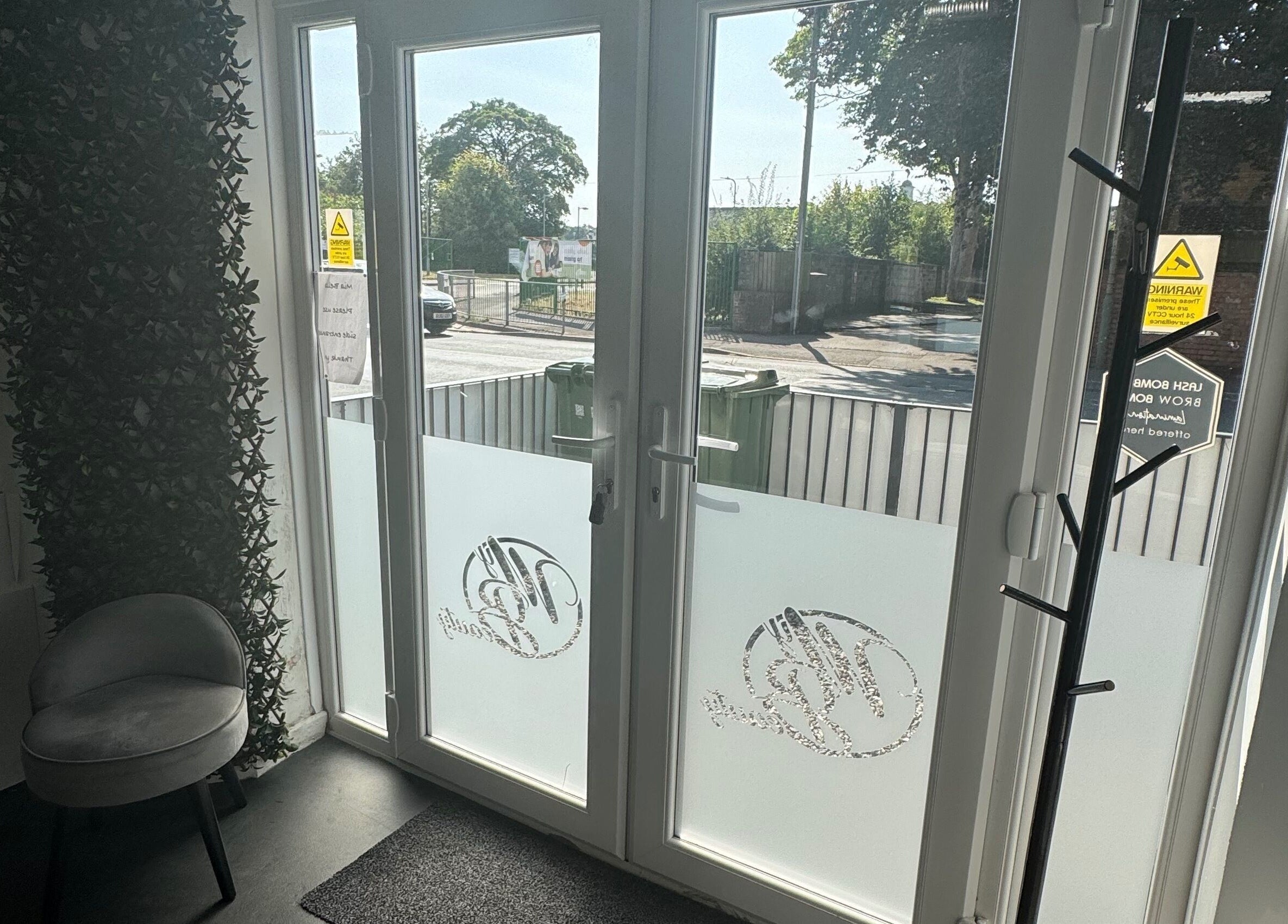 Bright entrance at Platinum HQ, Caerphilly, Wales, GB, featuring frosted glass doors and cozy seating.