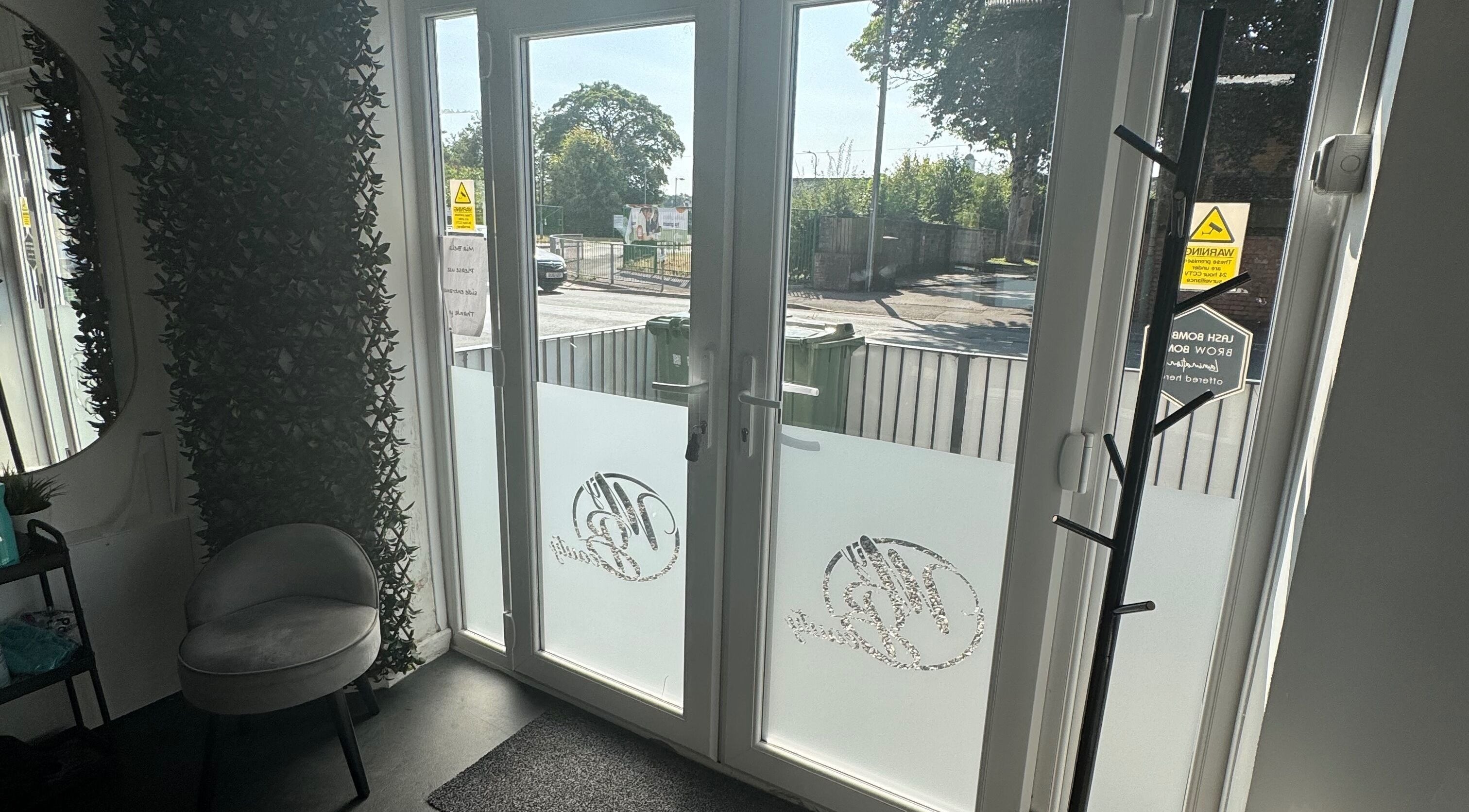 Bright entrance at Platinum HQ, Caerphilly, Wales, GB, featuring frosted glass doors and cozy seating.