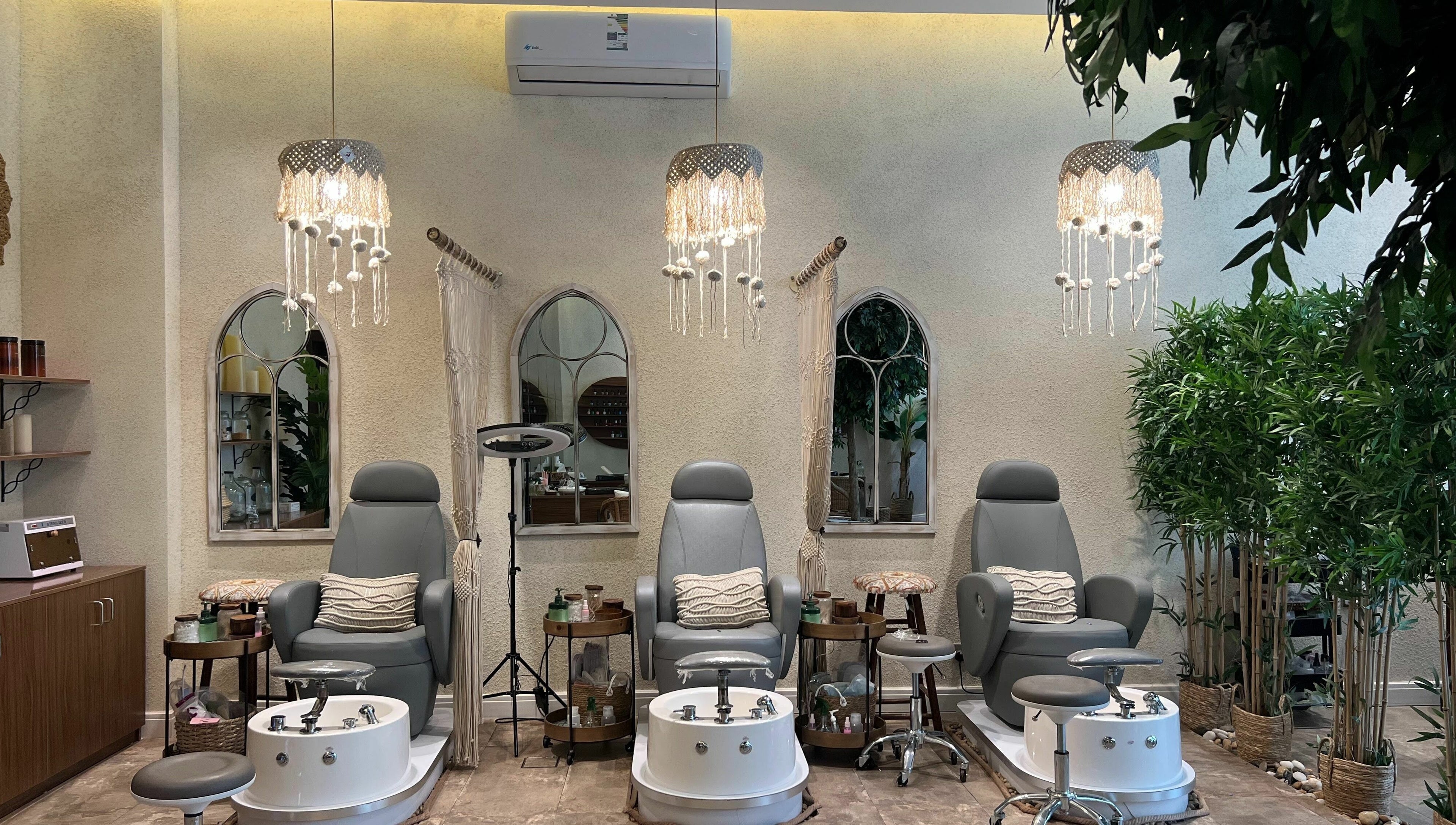 Cozy pedicure stations at Nails Oasis | واحة الاظافر, الرياض, منطقة الرياض, SA, under elegant chandeliers.