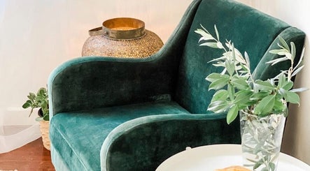 Green velvet chair with plants at Elements Bodyworks, Perth, Western Australia, AU, creating a relaxing space.