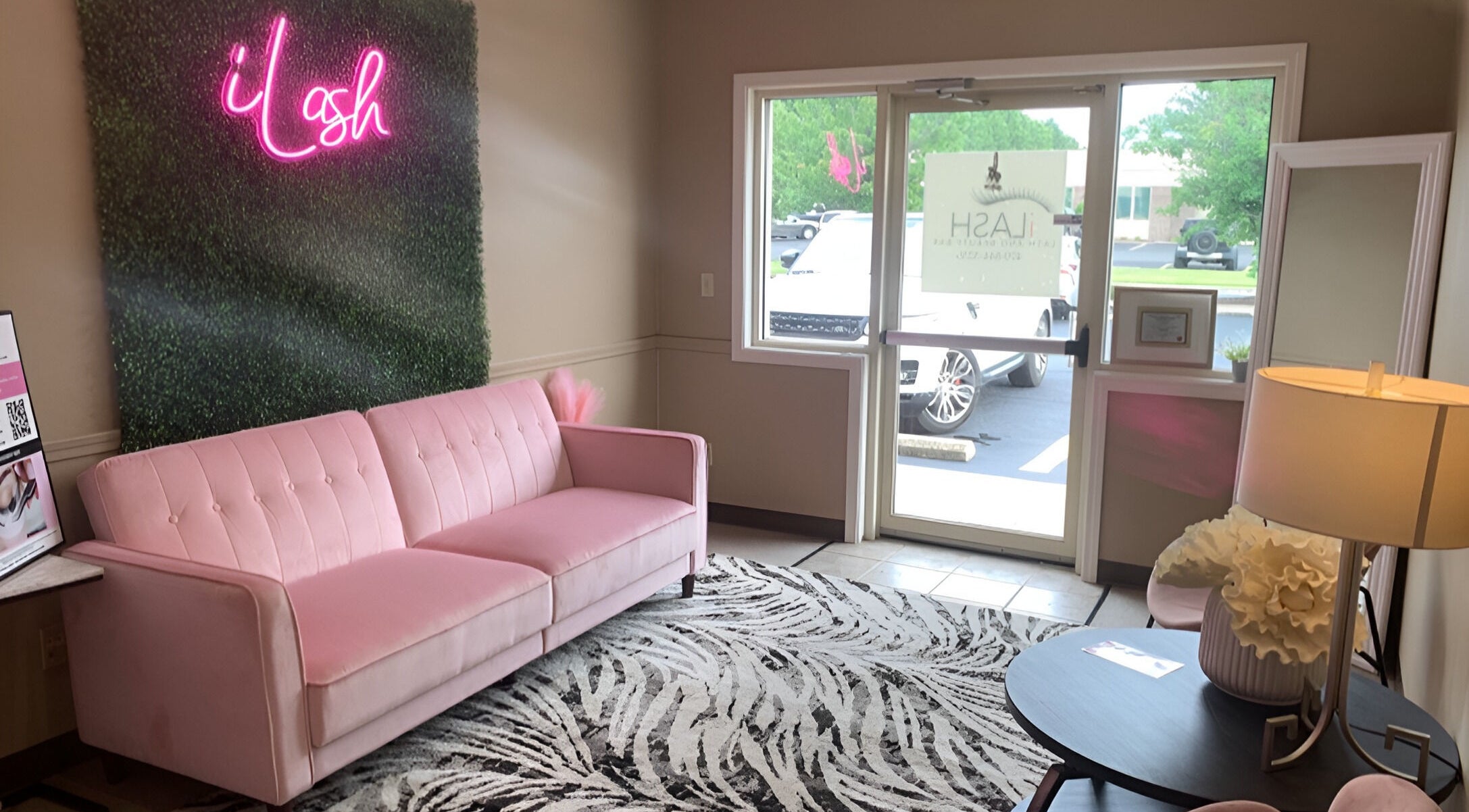 Chic pink sofa and neon sign at iLash Beauty Bar, Bentonville, Arkansas, US.