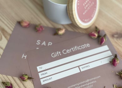 Gift certificates at Sarah Emily Holistics in Helpston, England, GB, with roses and candle for wellness ambiance.