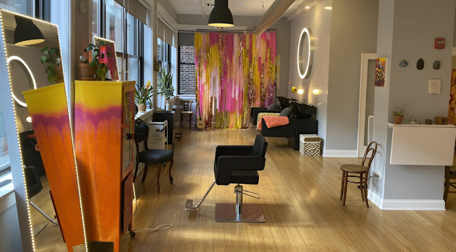 Inviting salon interior at Nina Ganci Hair in Providence, Rhode Island with colorful decor and modern styling chairs.