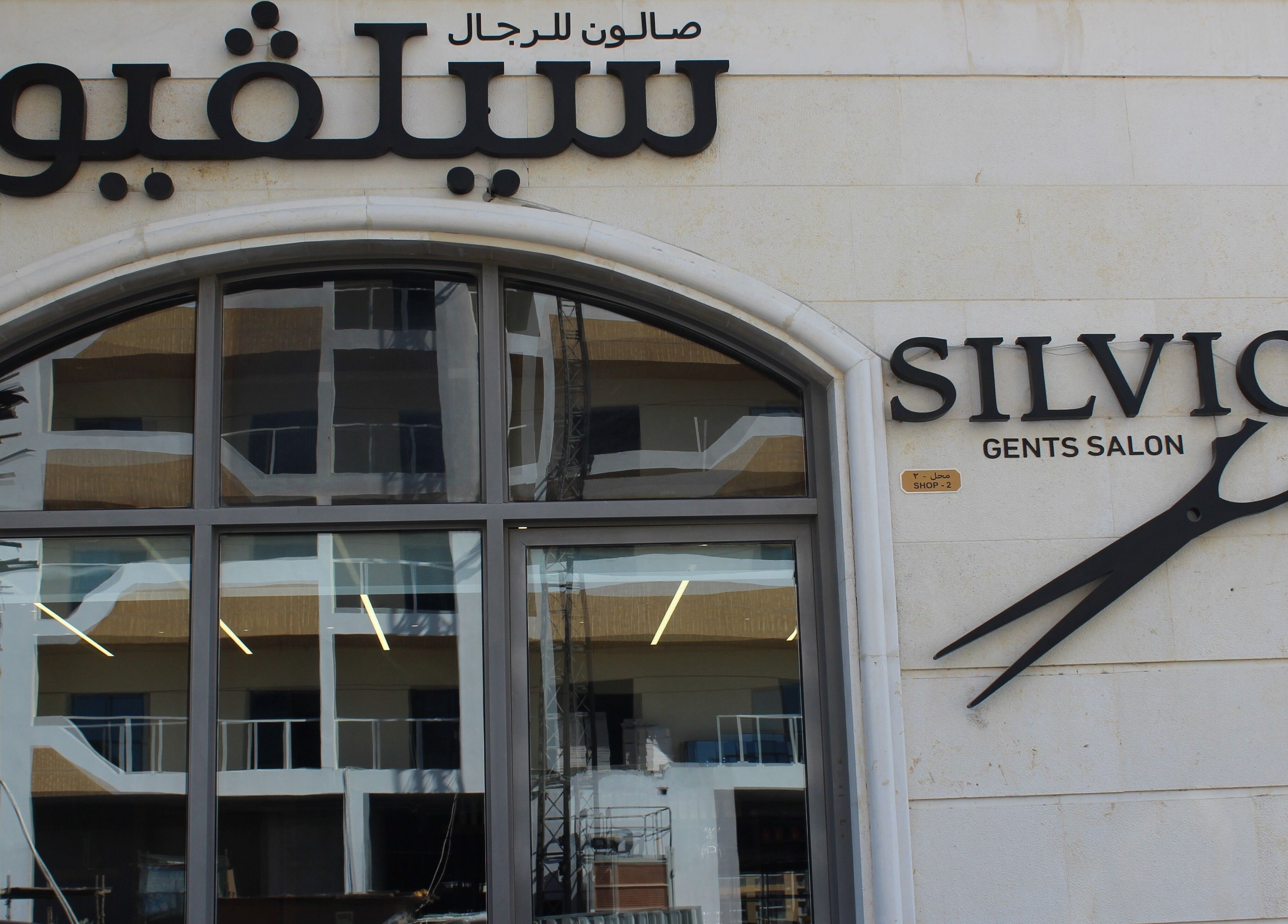 Front facade of Silvio Gents Salon in Dubai, AE, featuring stylish scissors logo and Arabic signage.