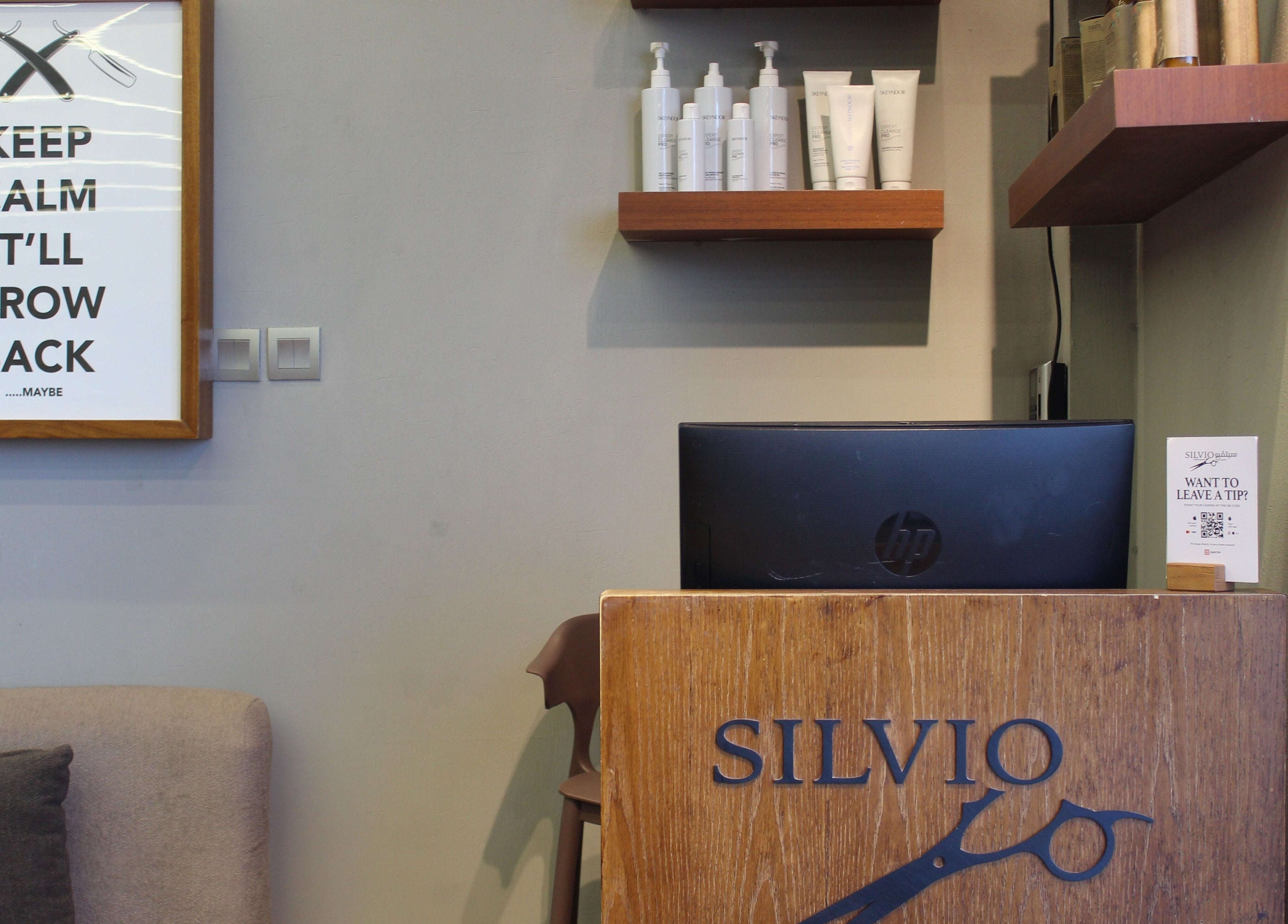 Reception area at Silvio Gents Salon, Dubai, featuring stylish decor and hair products display.