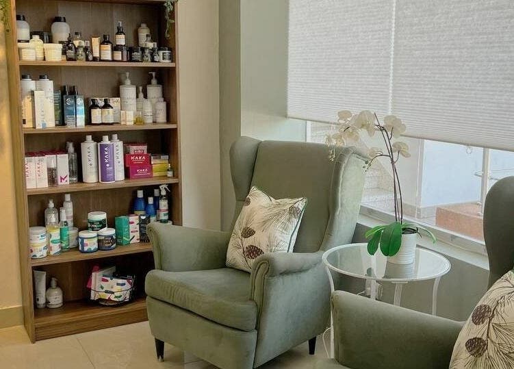 Espacio acogedor en Madiva Salón | Salón de belleza en San Cristóbal, San Cristóbal, DO. Sillones cómodos y estantería.