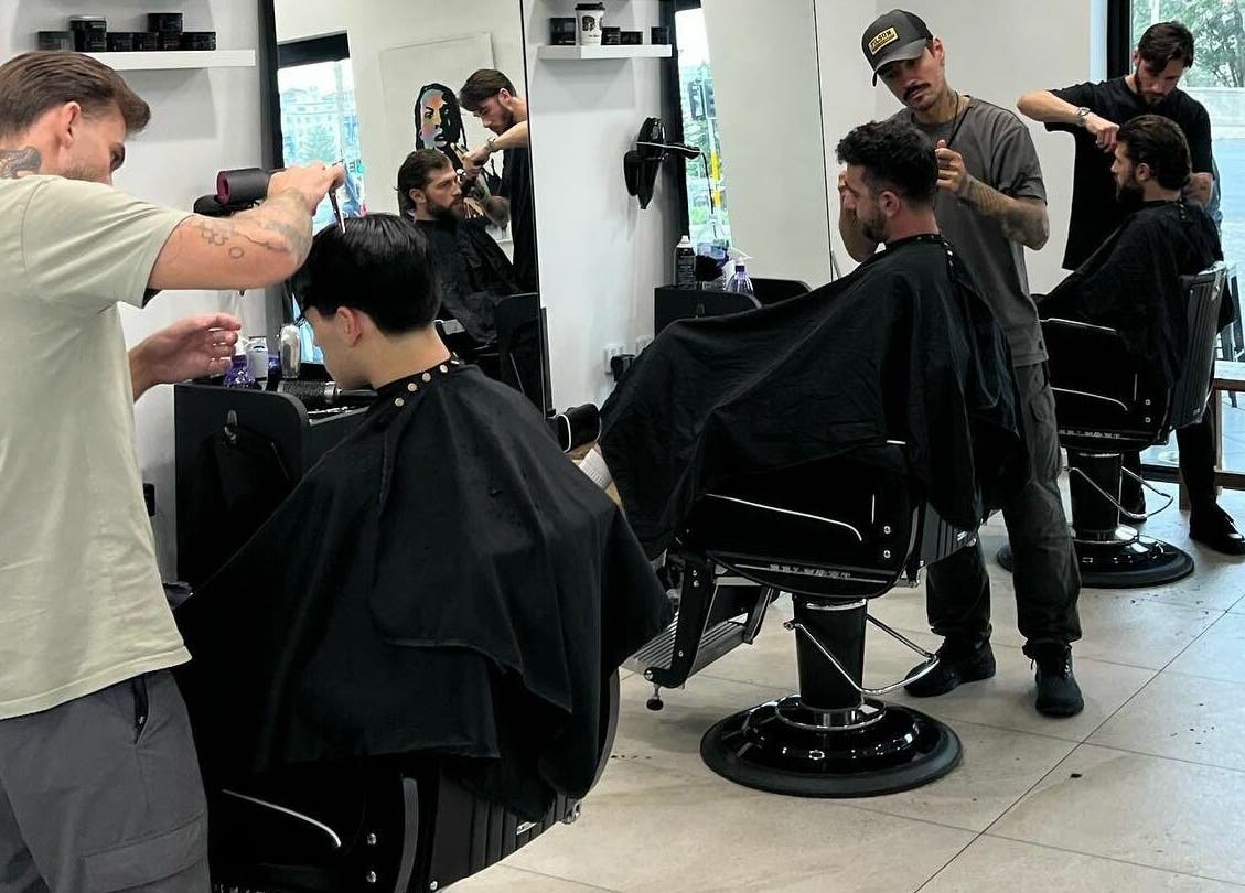 Professional barbers at AC FLO, Bondi Beach, New South Wales, AU, creating stylish haircuts in a modern salon.