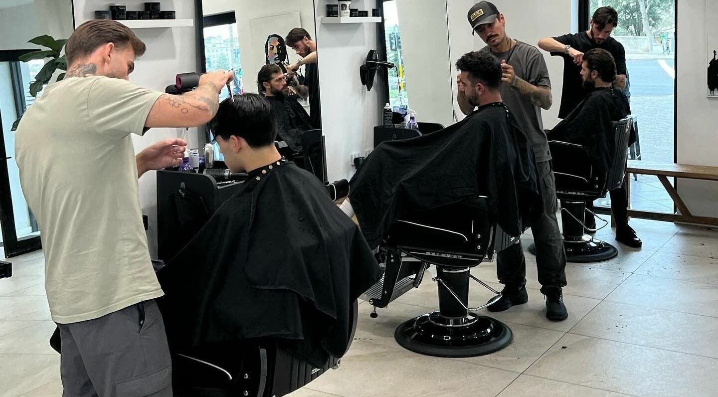 Professional barbers at AC FLO, Bondi Beach, New South Wales, AU, creating stylish haircuts in a modern salon.