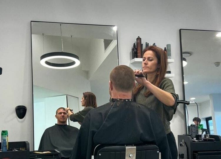 Woman expertly cutting hair at AC FLO Bondi Beach, New South Wales, AU in a modern salon setting.