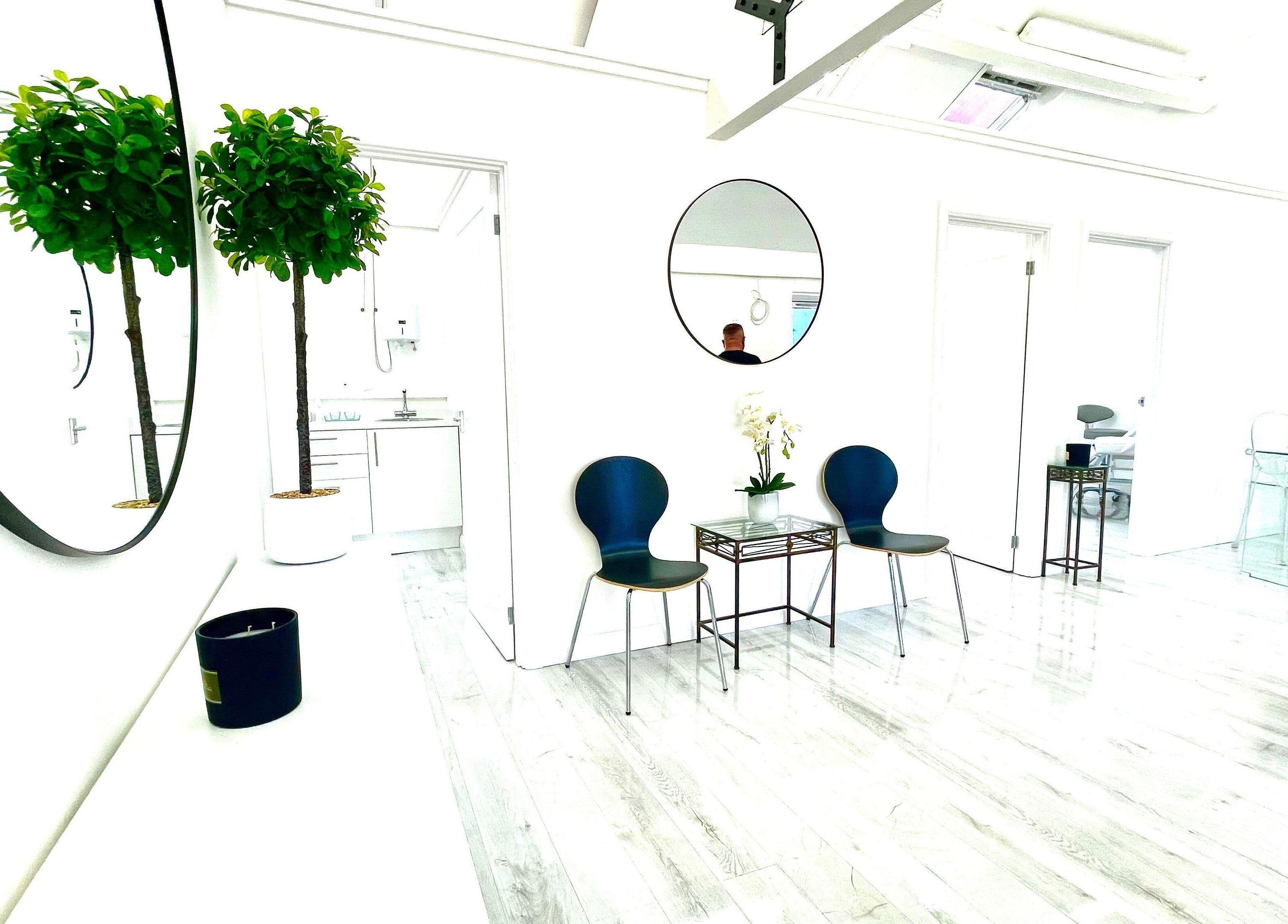 Elegant waiting area at Triggs and James Aesthetics in Swansea, Wales, GB featuring modern decor and lush greenery.