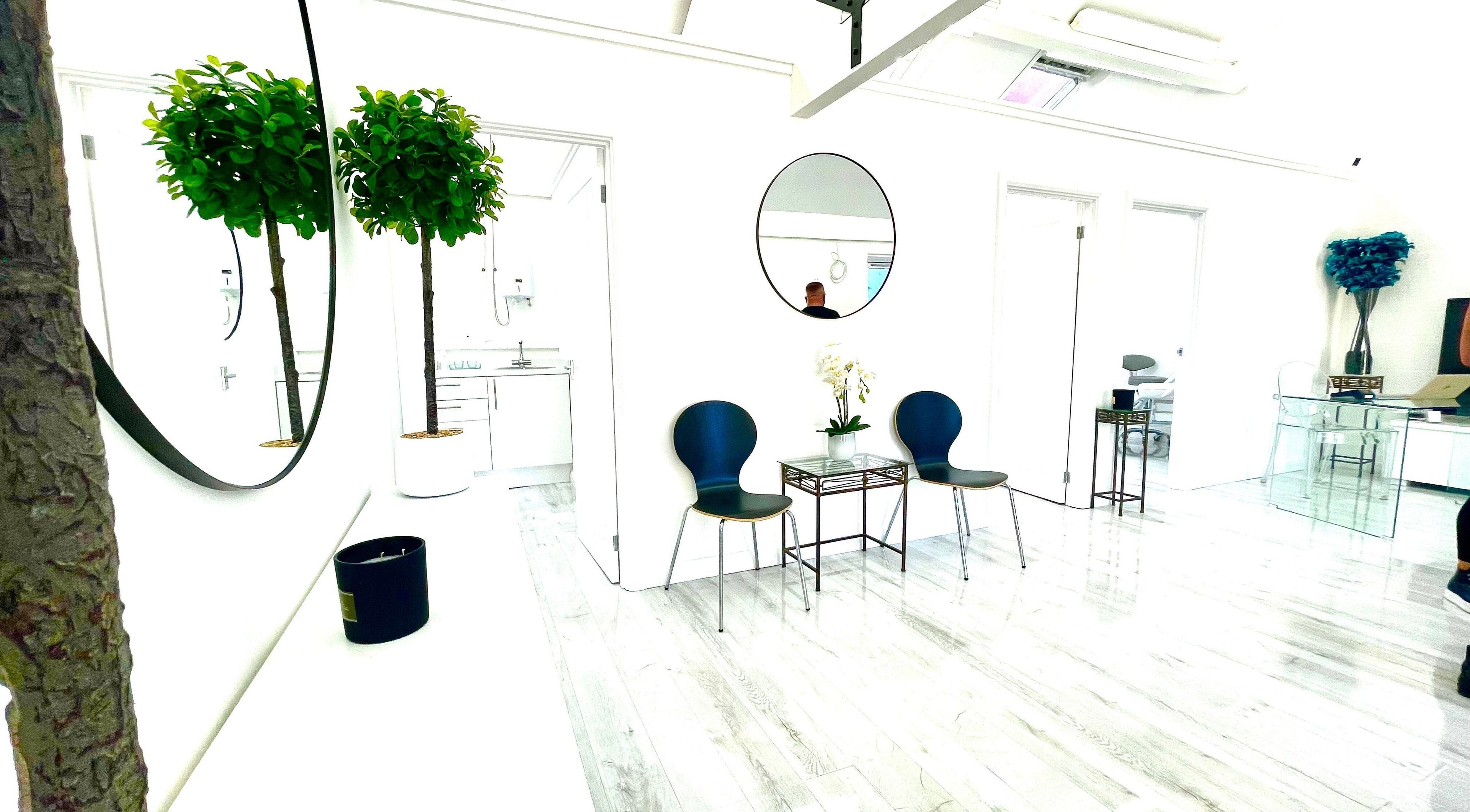 Elegant waiting area at Triggs and James Aesthetics in Swansea, Wales, GB featuring modern decor and lush greenery.