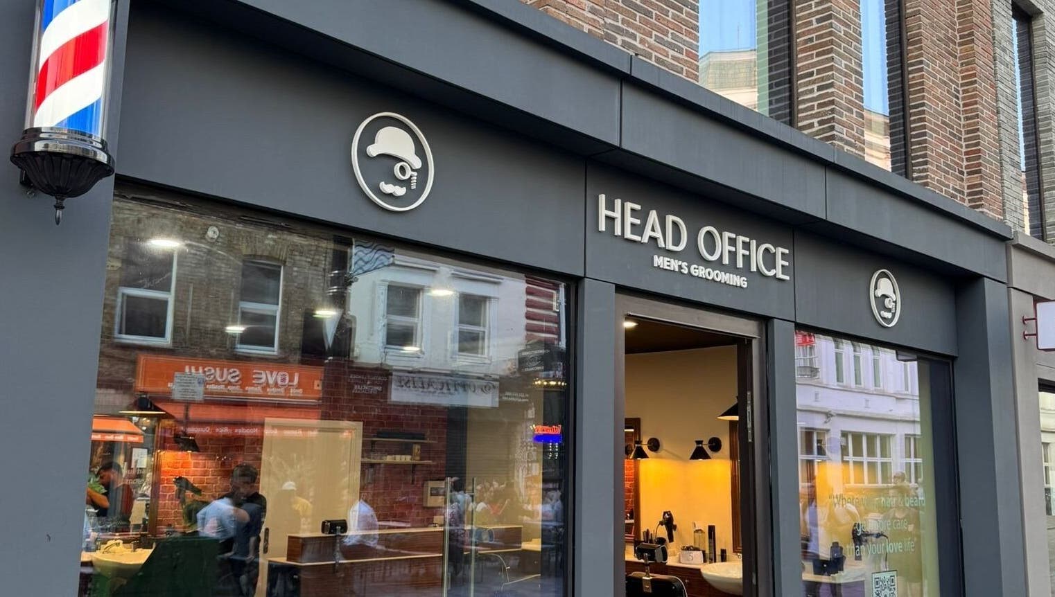 Front view of Head Office Men's Grooming - Waterloo in London, England, GB with a classic barber pole.