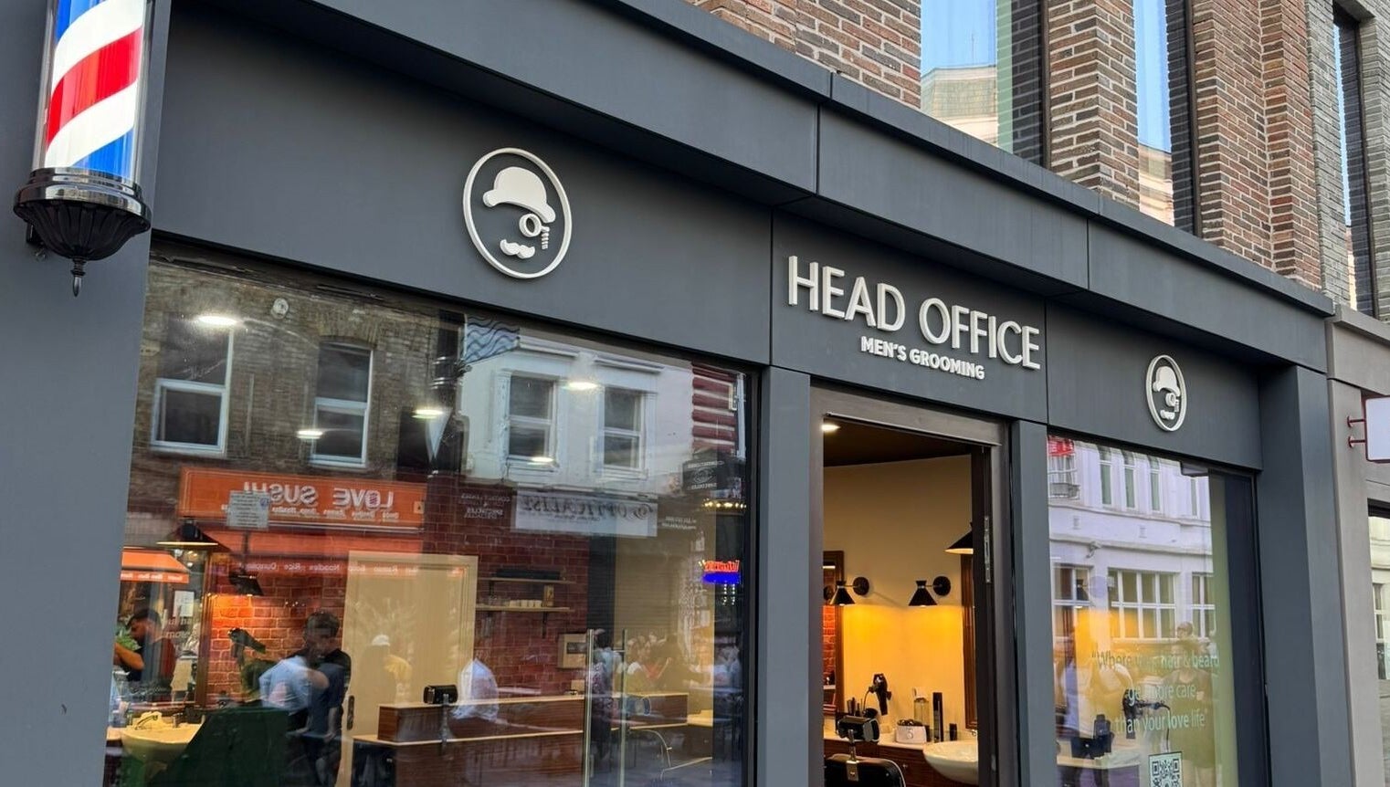 Front view of Head Office Men's Grooming - Waterloo in London, England, GB with a classic barber pole.