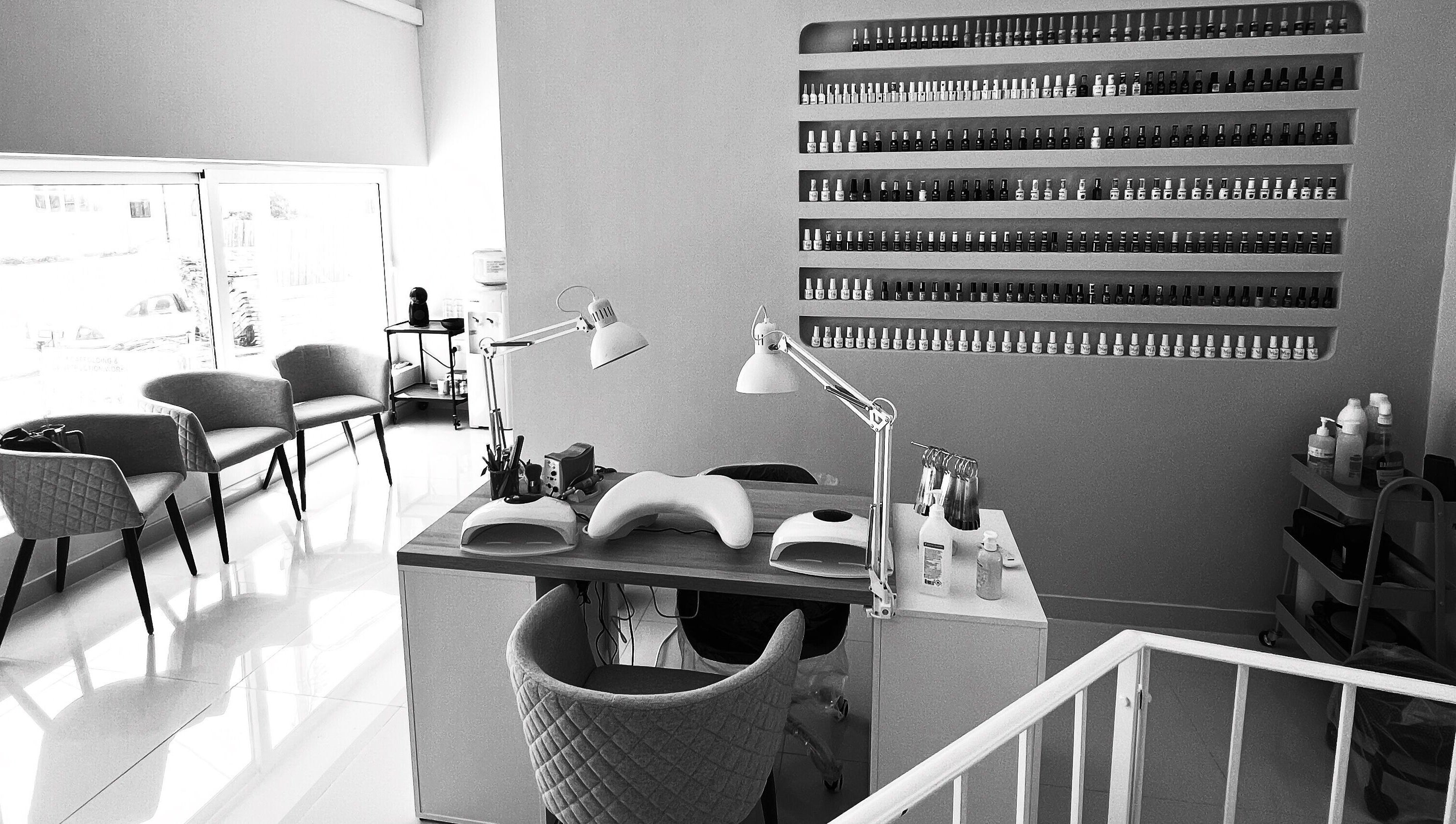 Modern nail salon setup at DC Beauty, In-naxxar, MT with stylish decor and well-organized polish displays.