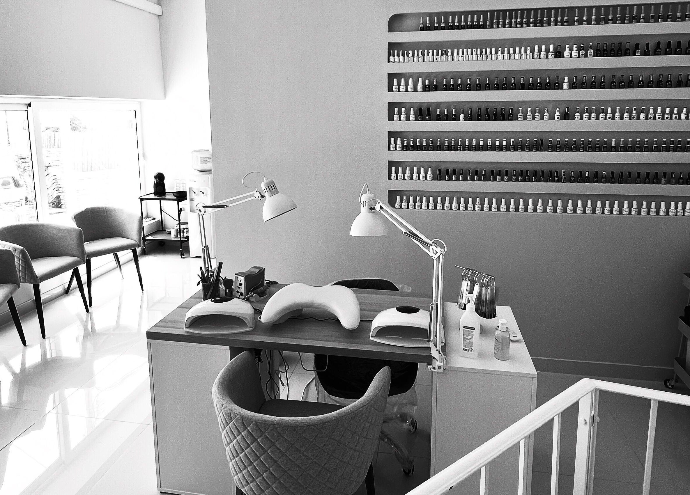 Modern nail salon setup at DC Beauty, In-naxxar, MT with stylish decor and well-organized polish displays.