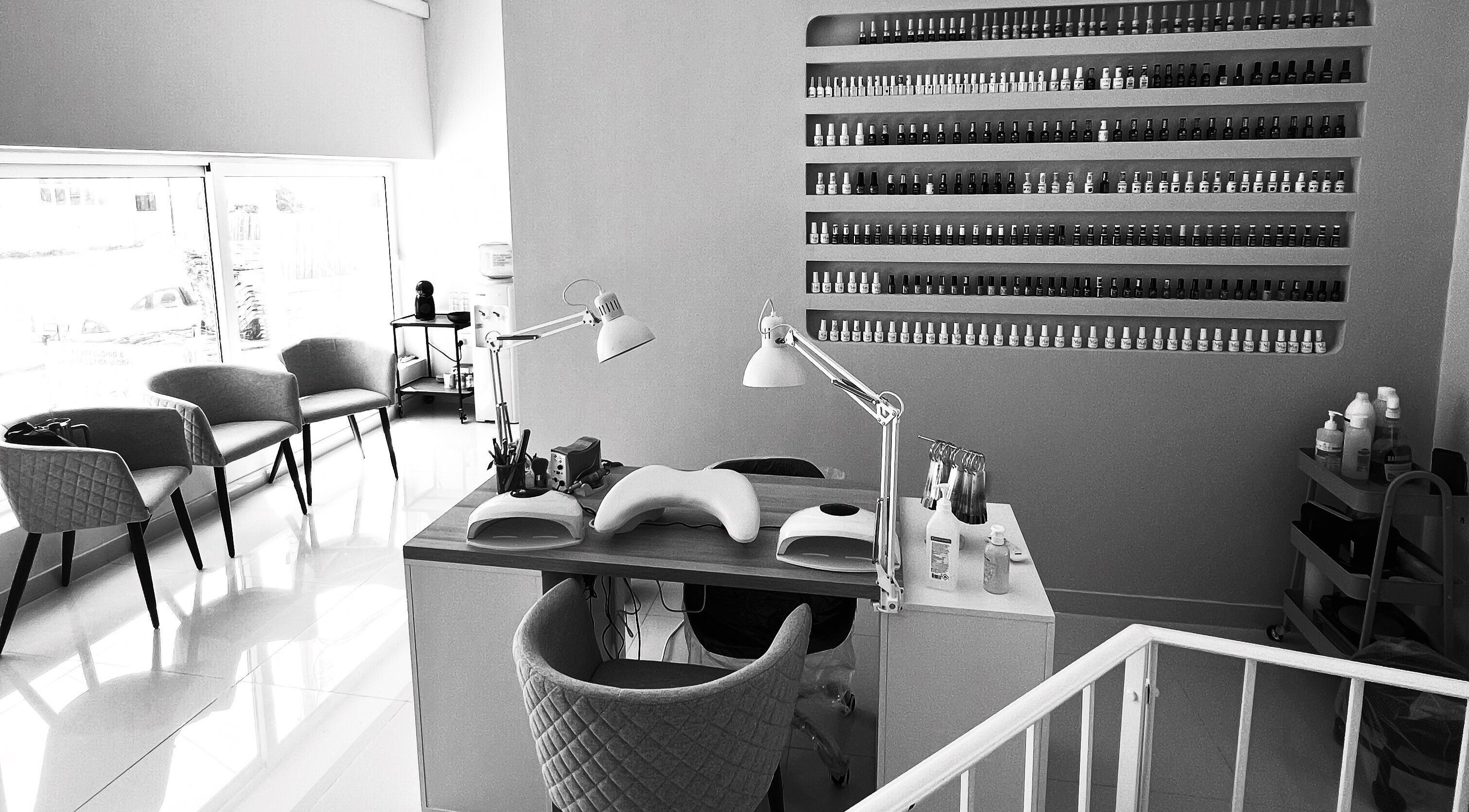 Modern nail salon setup at DC Beauty, In-naxxar, MT with stylish decor and well-organized polish displays.