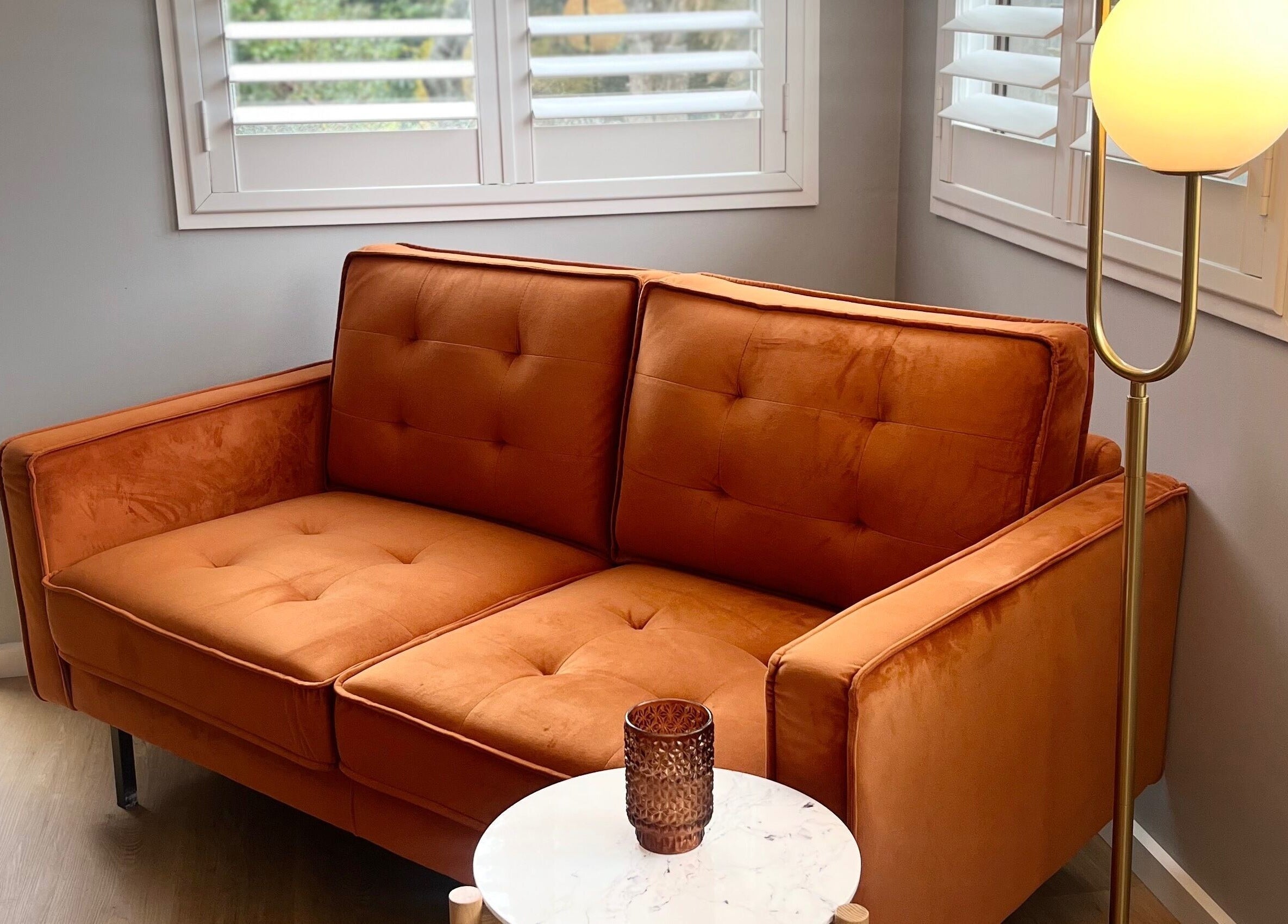 Cozy orange couch with ambient lighting at Skin Solace, Blackwood, Victoria, AU, inviting relaxation.