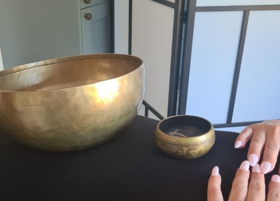 Close-up of a hand near Tibetan singing bowls at Hammersmith W6 8HS for relaxation in London, England, GB.