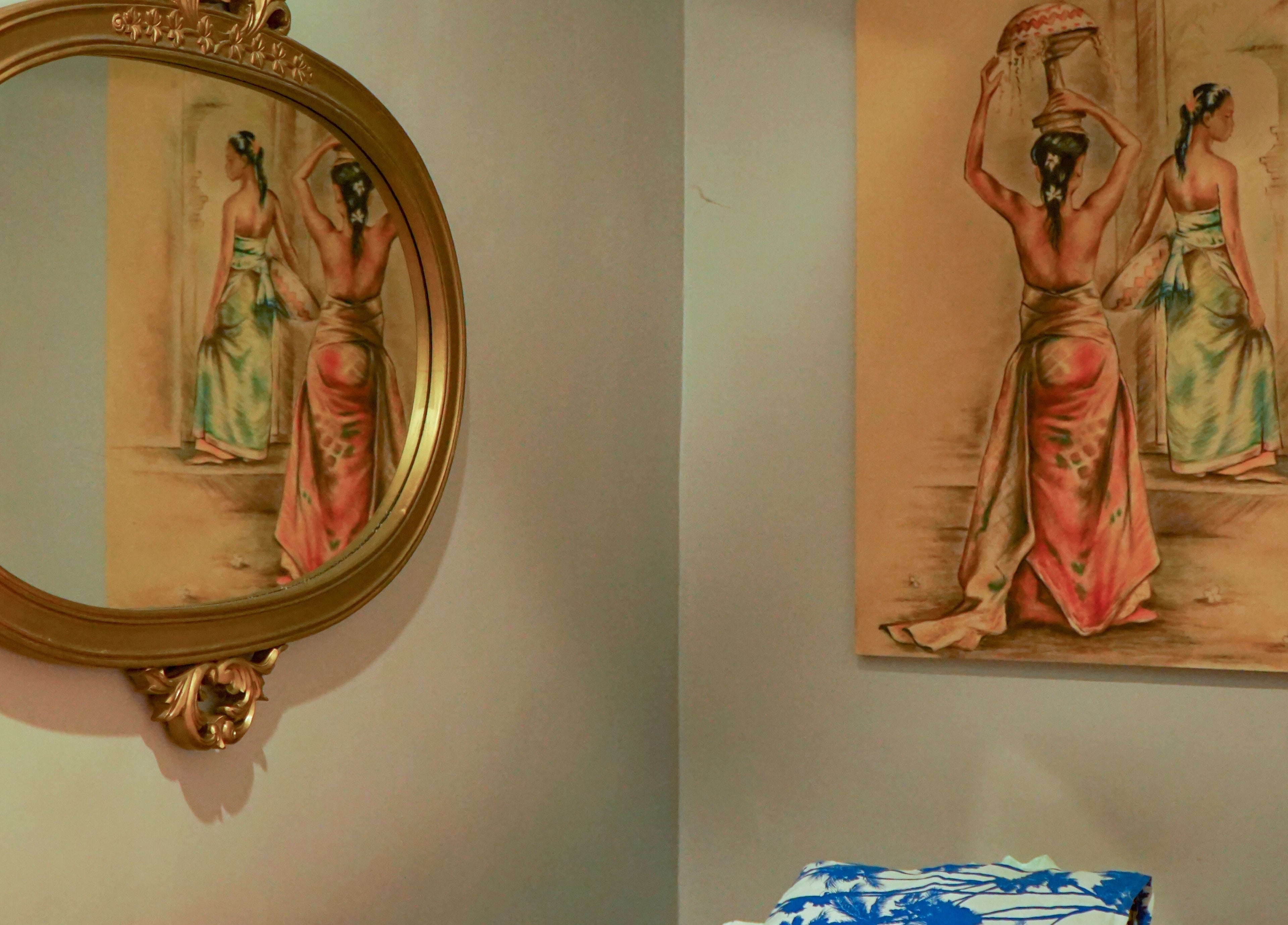 A classic Balinese painting reflected in an ornate mirror at Peni Weni, Bali, Bali, ID.