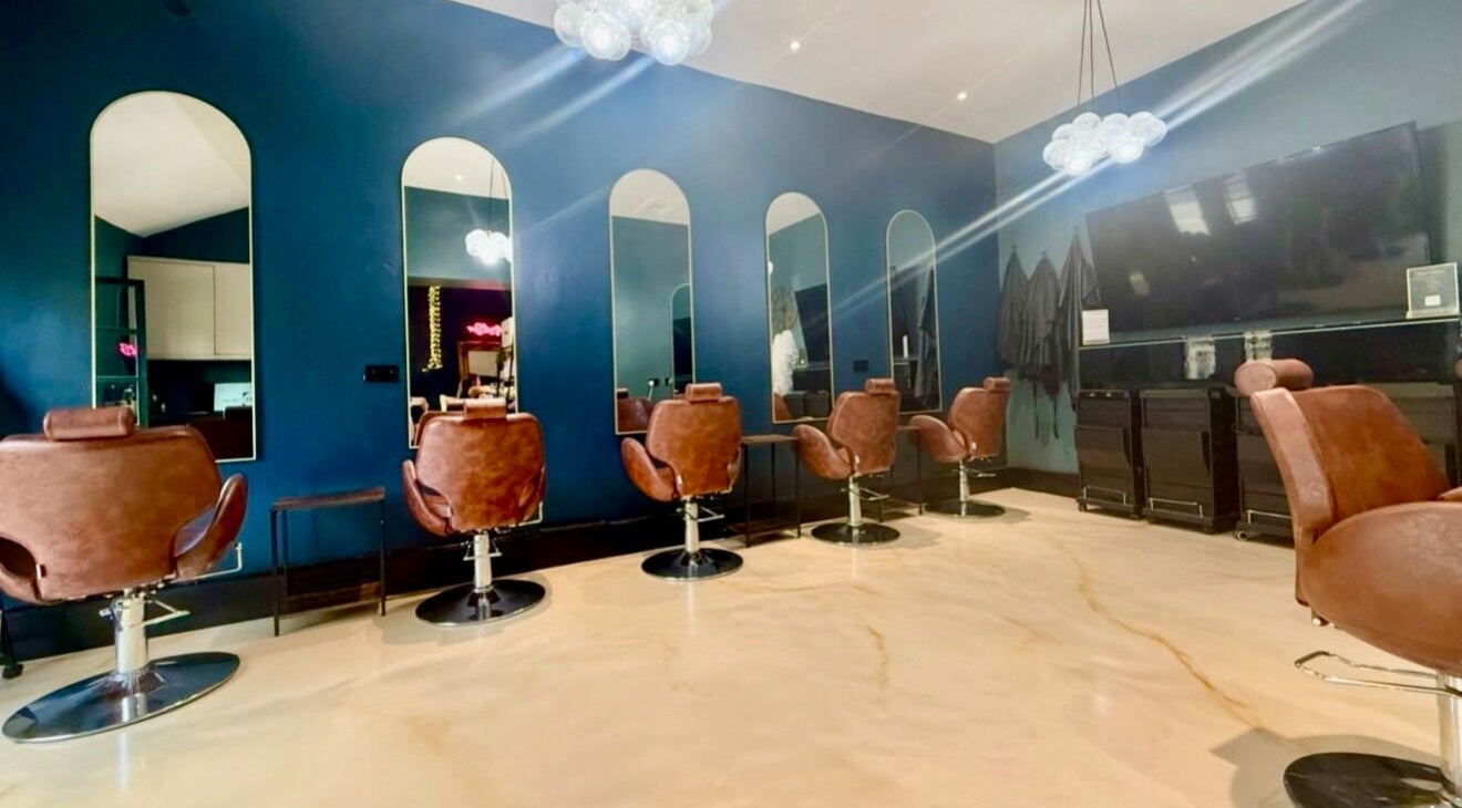 Stylish interior of The Hair & Makeup Project, Ilkley, England, GB with sleek mirrors and leather chairs.