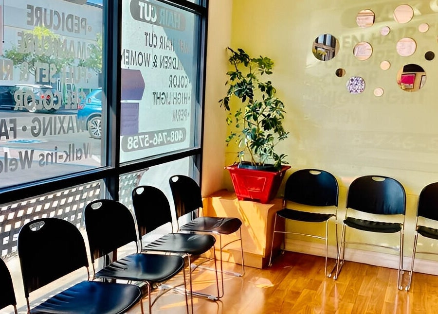 Bright seating area at Amazing Cuts, Sunnyvale, California, featuring chairs and decorative wall mirrors.