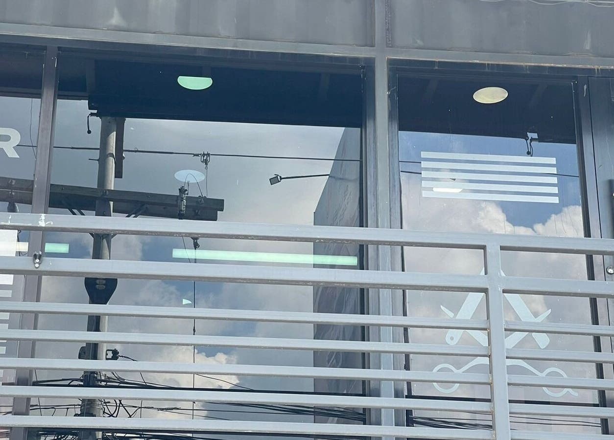 Fachada de Garbo Container en San Pedro Sula, HN con reflejos en vidrio y diseño moderno.