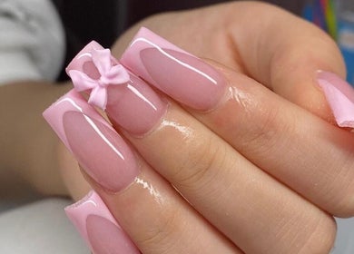 Manicura rosada con lazo en Wow Salón, Tijuana, Baja California, MX. Elegancia y detalle en cada uña.