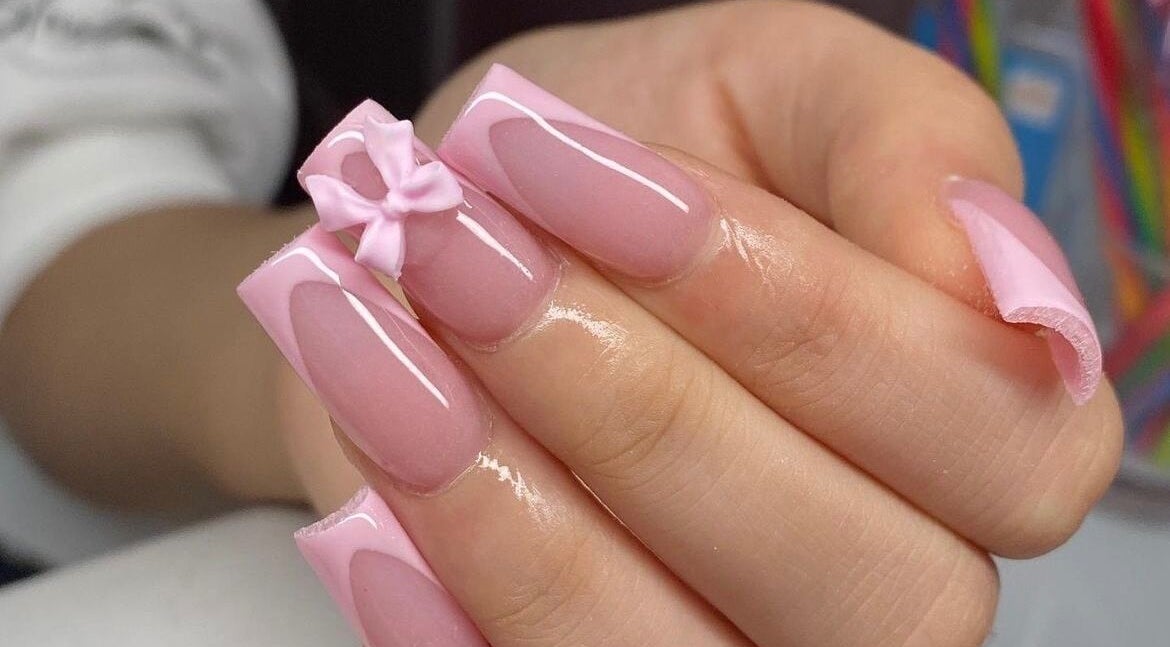 Manicura rosada con lazo en Wow Salón, Tijuana, Baja California, MX. Elegancia y detalle en cada uña.