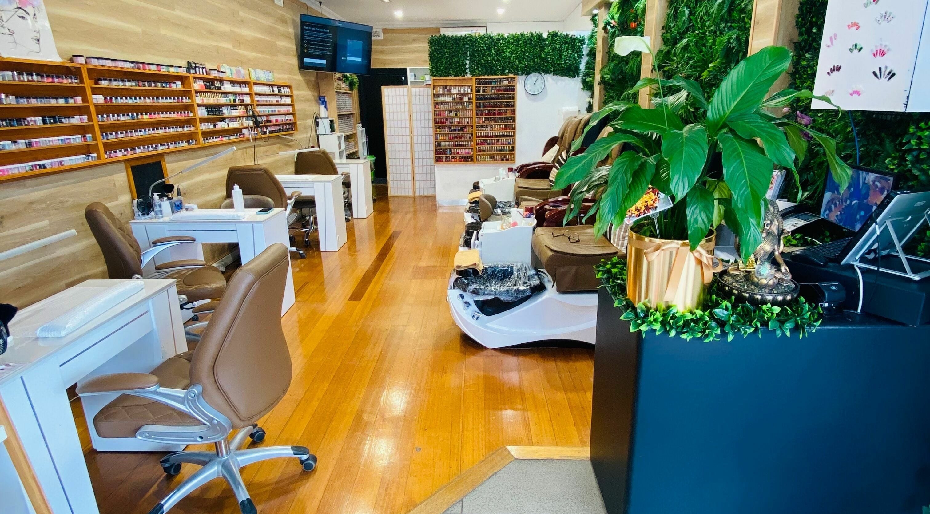 Elegant interior of JG's Nail Spa & Beauty in Melbourne, Victoria, AU with stylish nail stations and lush greenery.