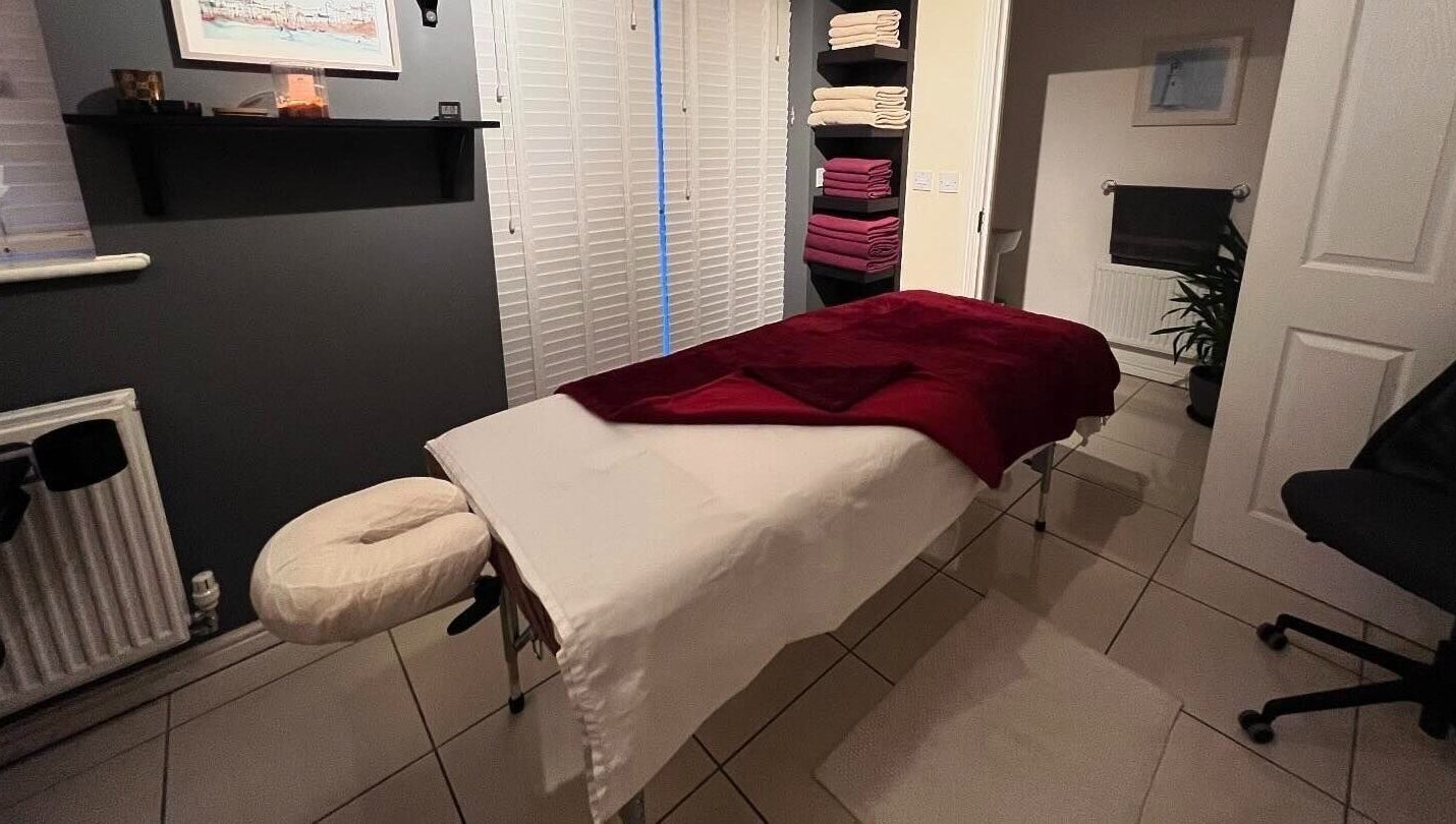 Tranquil massage room at Elysian Therapies, South Ockendon, GB with a massage table and soft lighting.