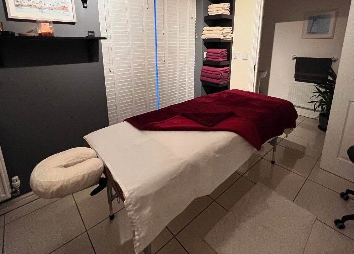 Tranquil massage room at Elysian Therapies, South Ockendon, GB with a massage table and soft lighting.