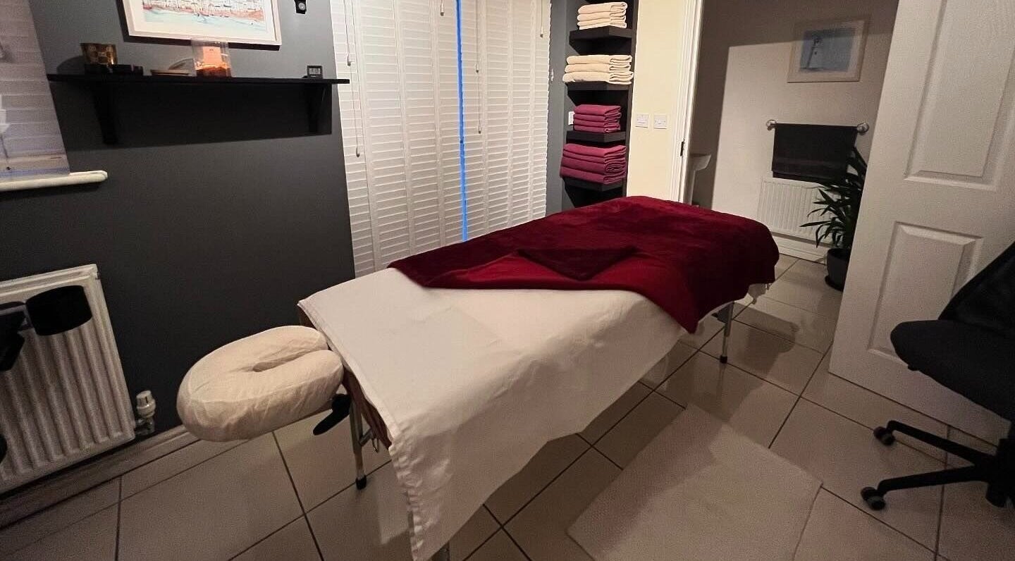 Tranquil massage room at Elysian Therapies, South Ockendon, GB with a massage table and soft lighting.