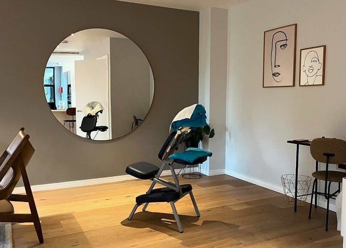 Tranquil therapy room at Elysian Therapies in South Ockendon, GB, featuring massage chair and abstract art.