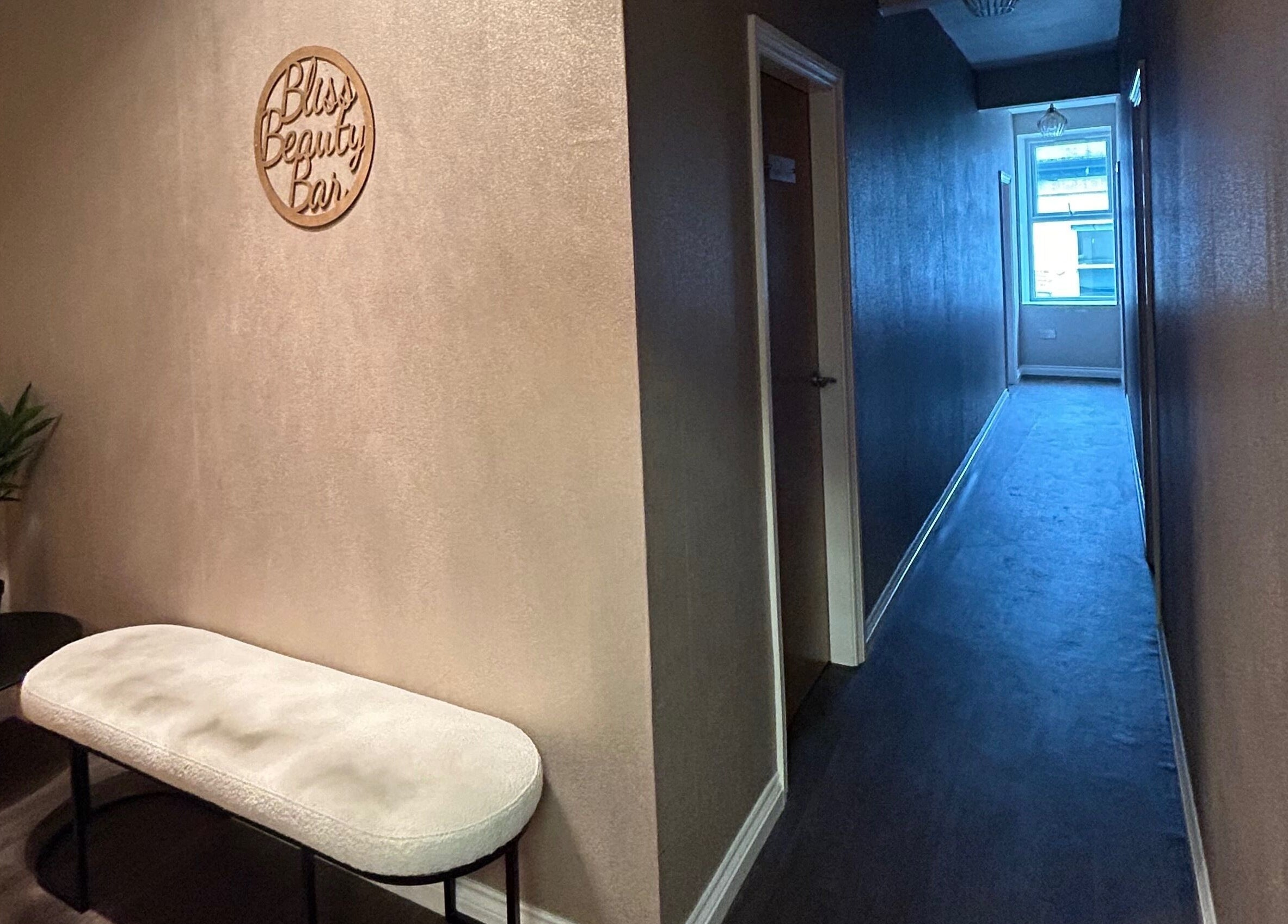 Serene hallway at Bliss Beauty Bar, Ramsey, Ramsey, IM, with decor and seating.