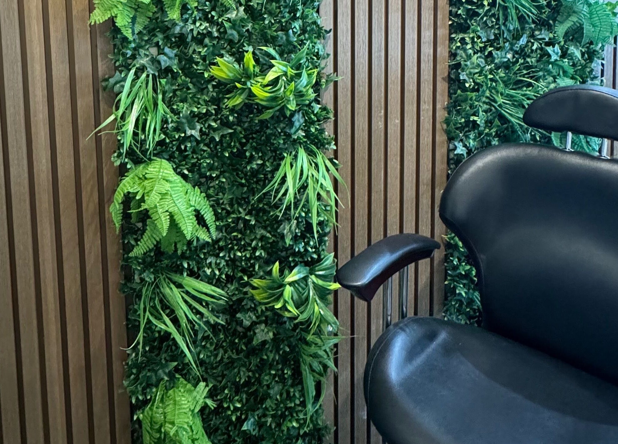 Spa chair beside lush green wall at Bliss Beauty Bar, Ramsey, Ramsey, IM for a serene experience.