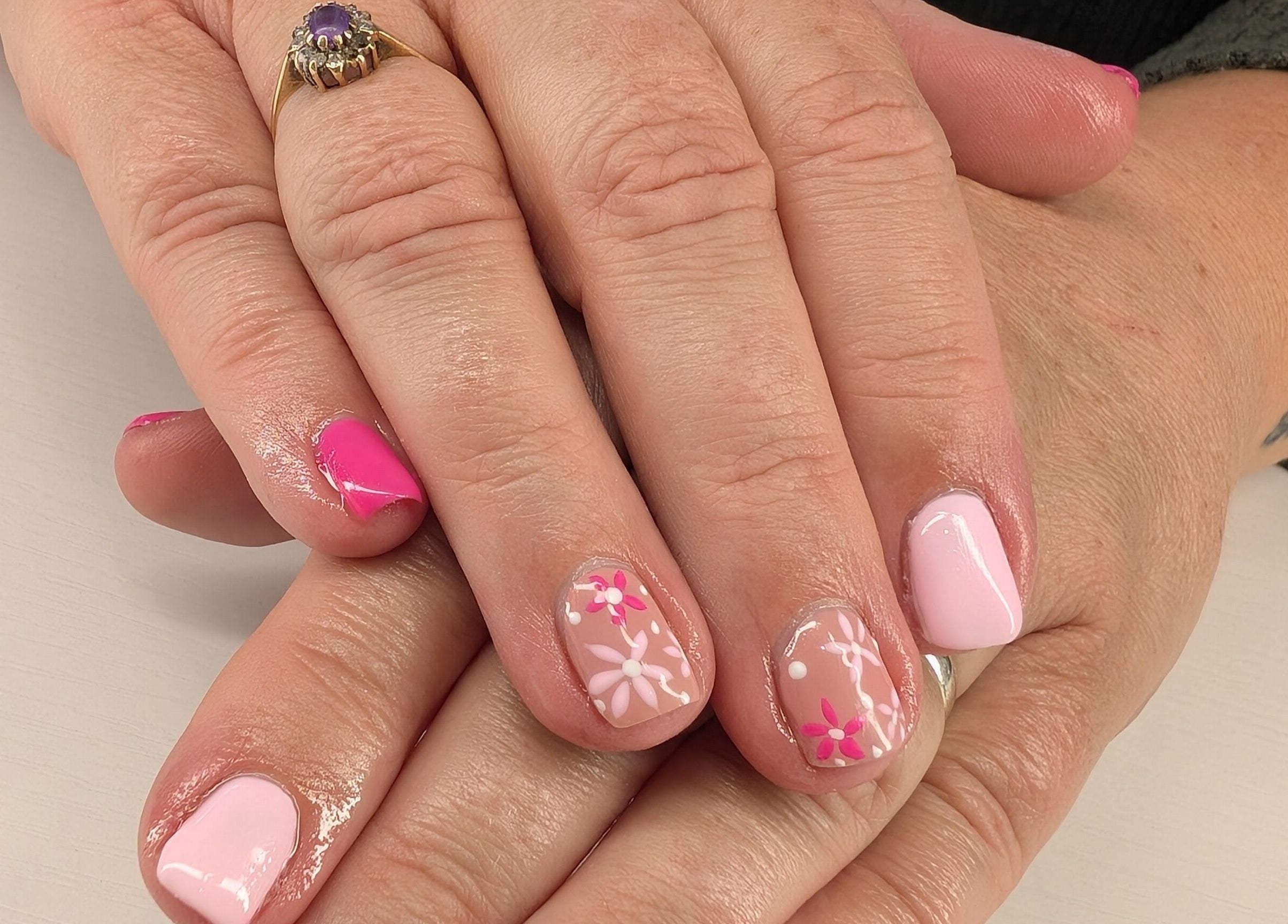 Floral nail art manicure at Beyond Beauty, Blyth, England, GB showcasing intricate pink and white designs.