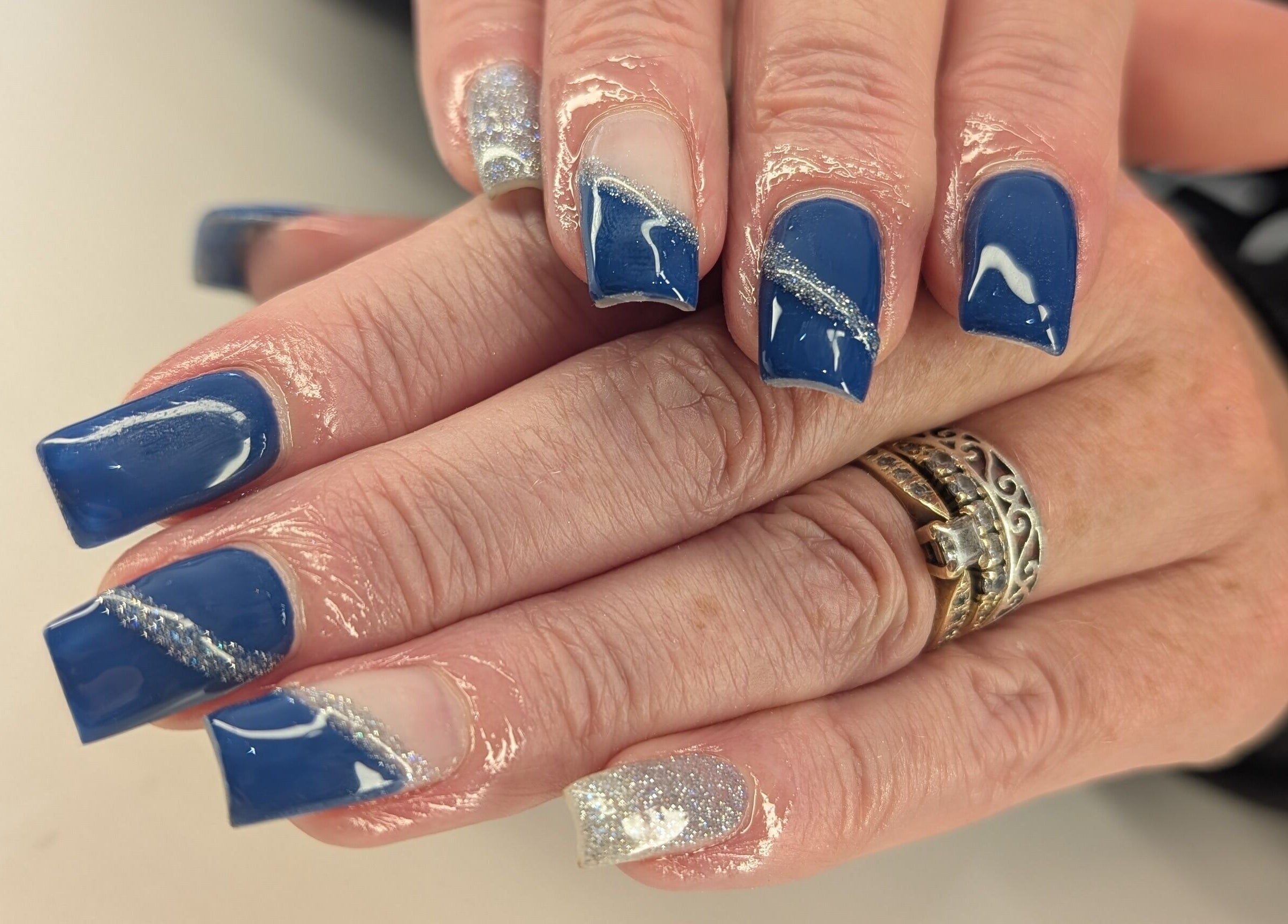 Blue and glitter acrylic nails at Beyond Beauty in Blyth, England, GB