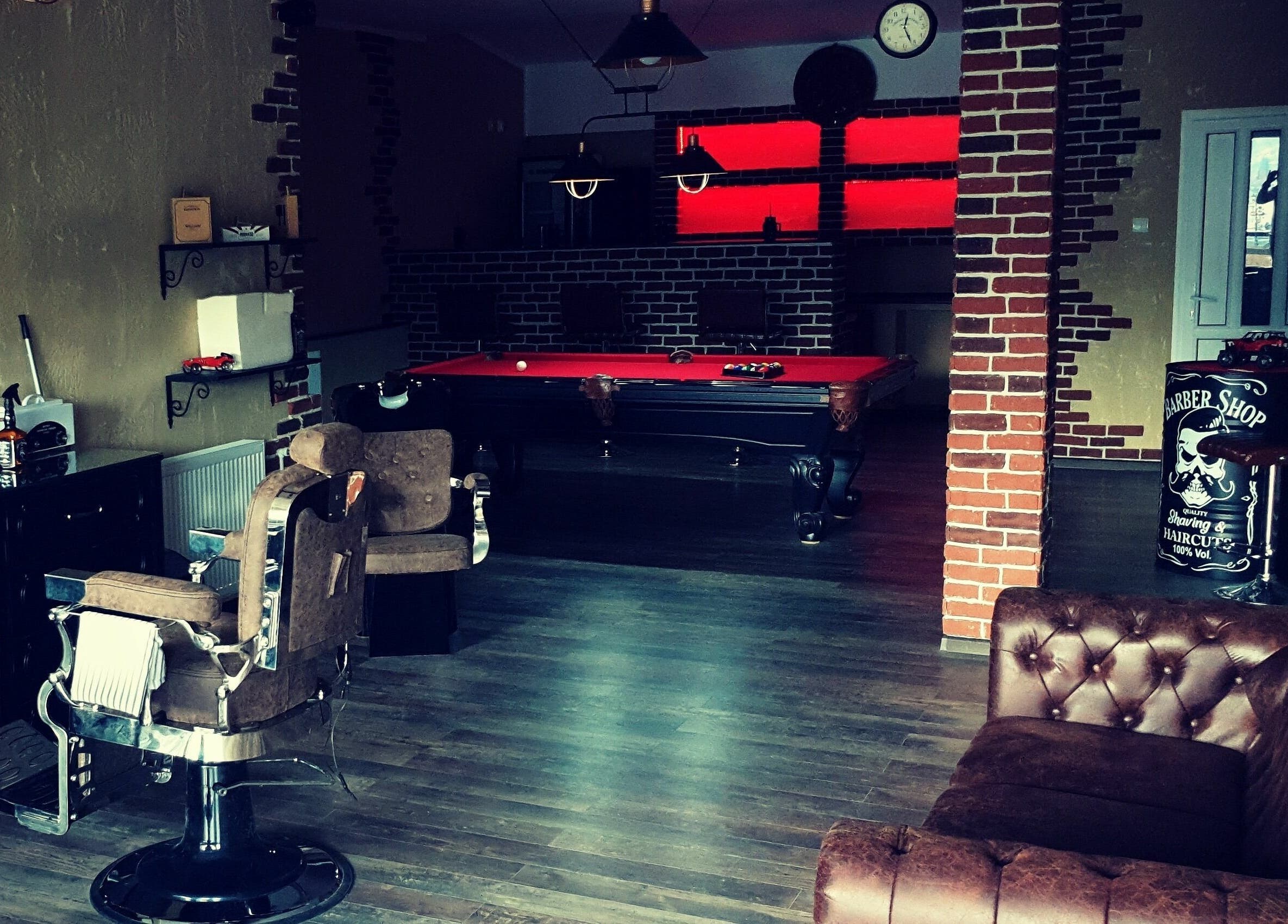 Interiorul Filaret's Barbershop din Gura Humorului, România, cu scaune de frizerie și masă de biliard.