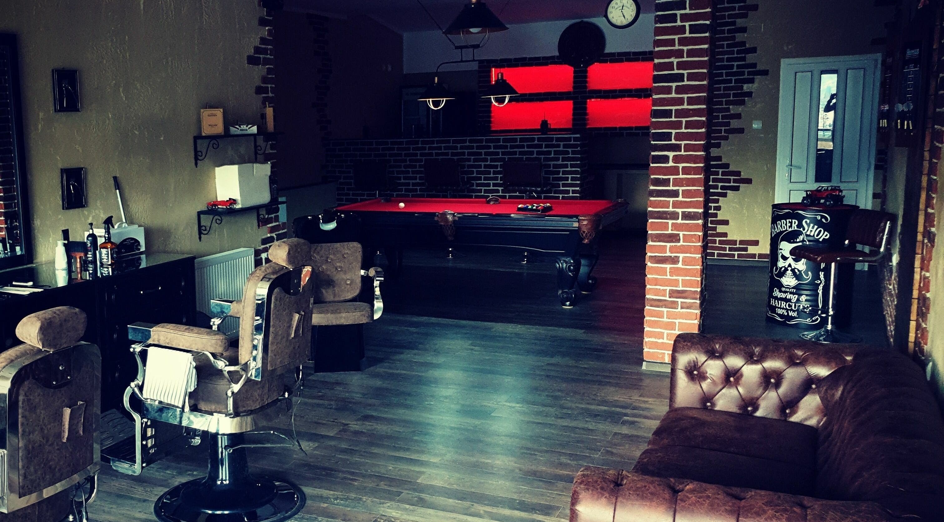 Interiorul Filaret's Barbershop din Gura Humorului, România, cu scaune de frizerie și masă de biliard.