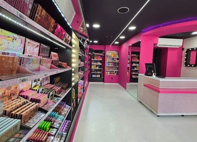 Εσωτερικός χώρος του W7 Make Up Proffesional στην Αχαρνές, GR με έντονα χρώματα και εκτεταμένη συλλογή καλλυντικών.