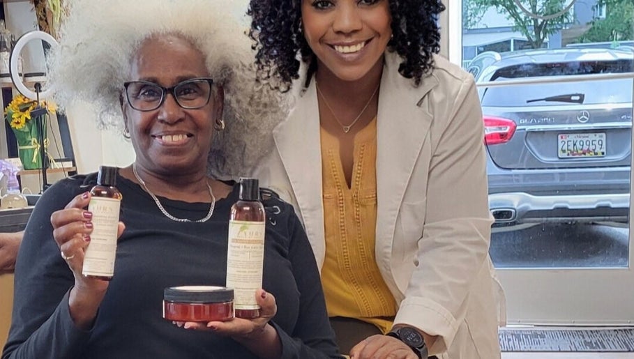 Happy client and specialist at A'daora Trichology & Wellness Inst., Towson, Maryland, US, showcasing hair products.