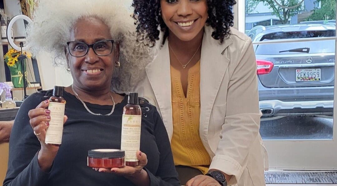 Happy client and specialist at A'daora Trichology & Wellness Inst., Towson, Maryland, US, showcasing hair products.