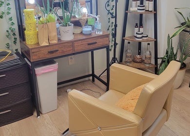 Cozy beauty station at A'daora Trichology & Wellness Inst., Towson, Maryland, US, with a plush chair and plants.