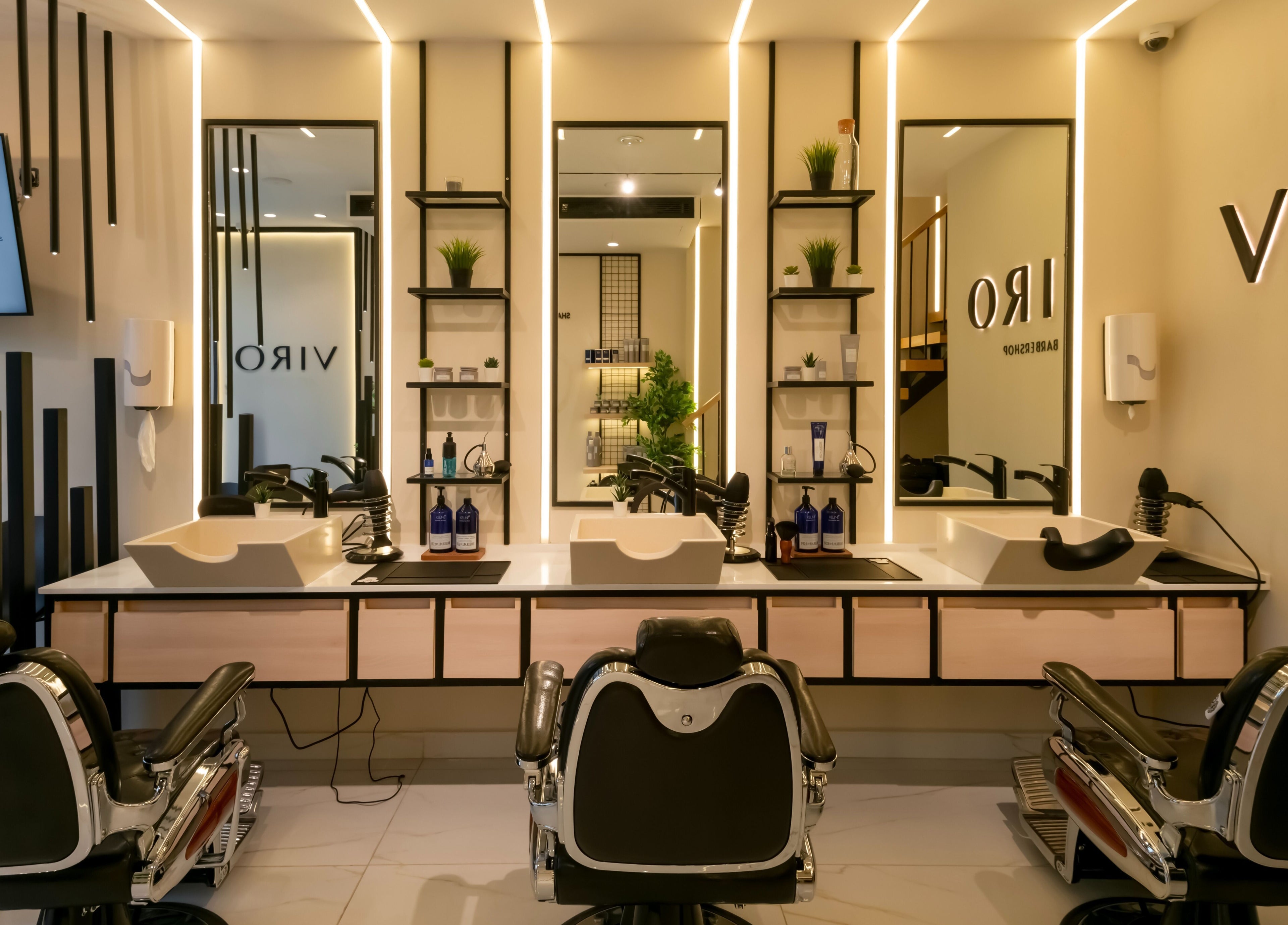 Modern interior of VIRO Barbershop - AL Nakheel in Amman, featuring sleek chairs and mirrors.