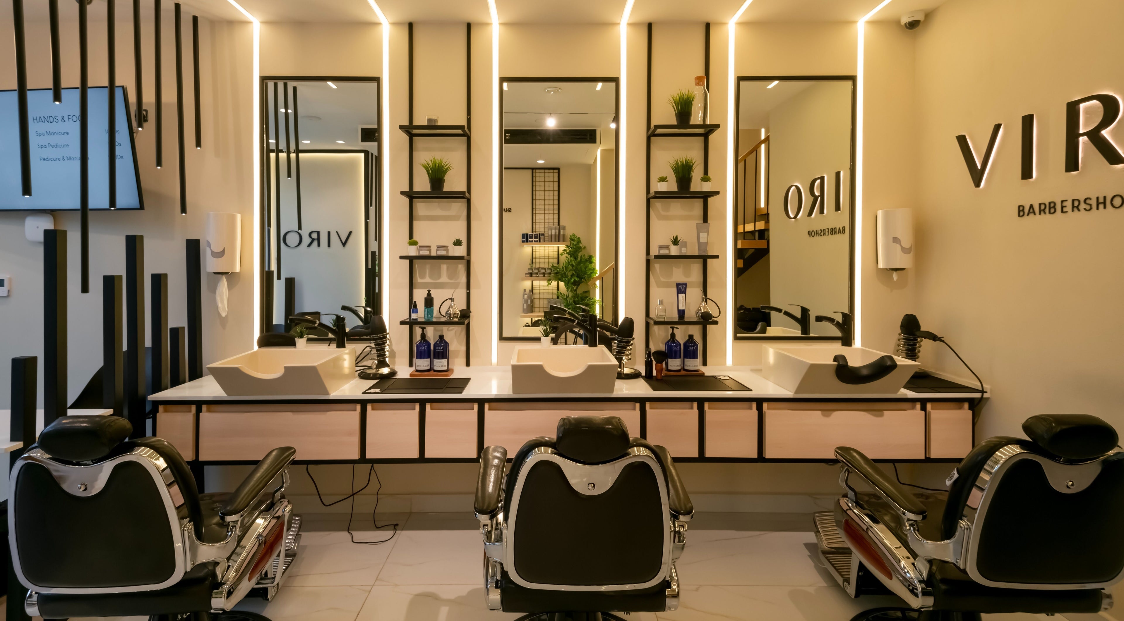 Modern interior of VIRO Barbershop - AL Nakheel in Amman, featuring sleek chairs and mirrors.
